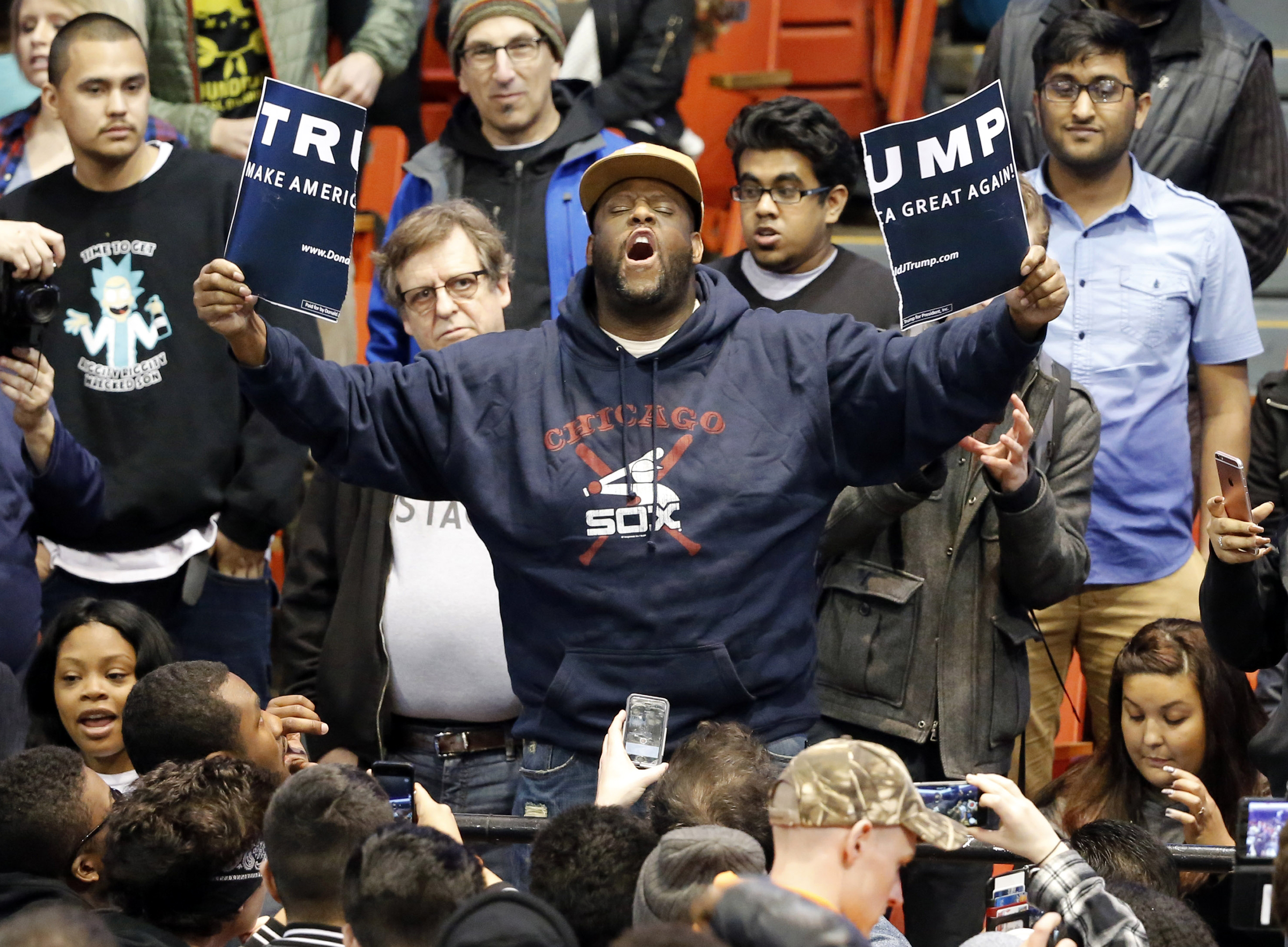 A protester held up a ripped campaign sign for GOP presidential candidate Donald Trump before a rally on the campus of the University of Illinois-Chicago.