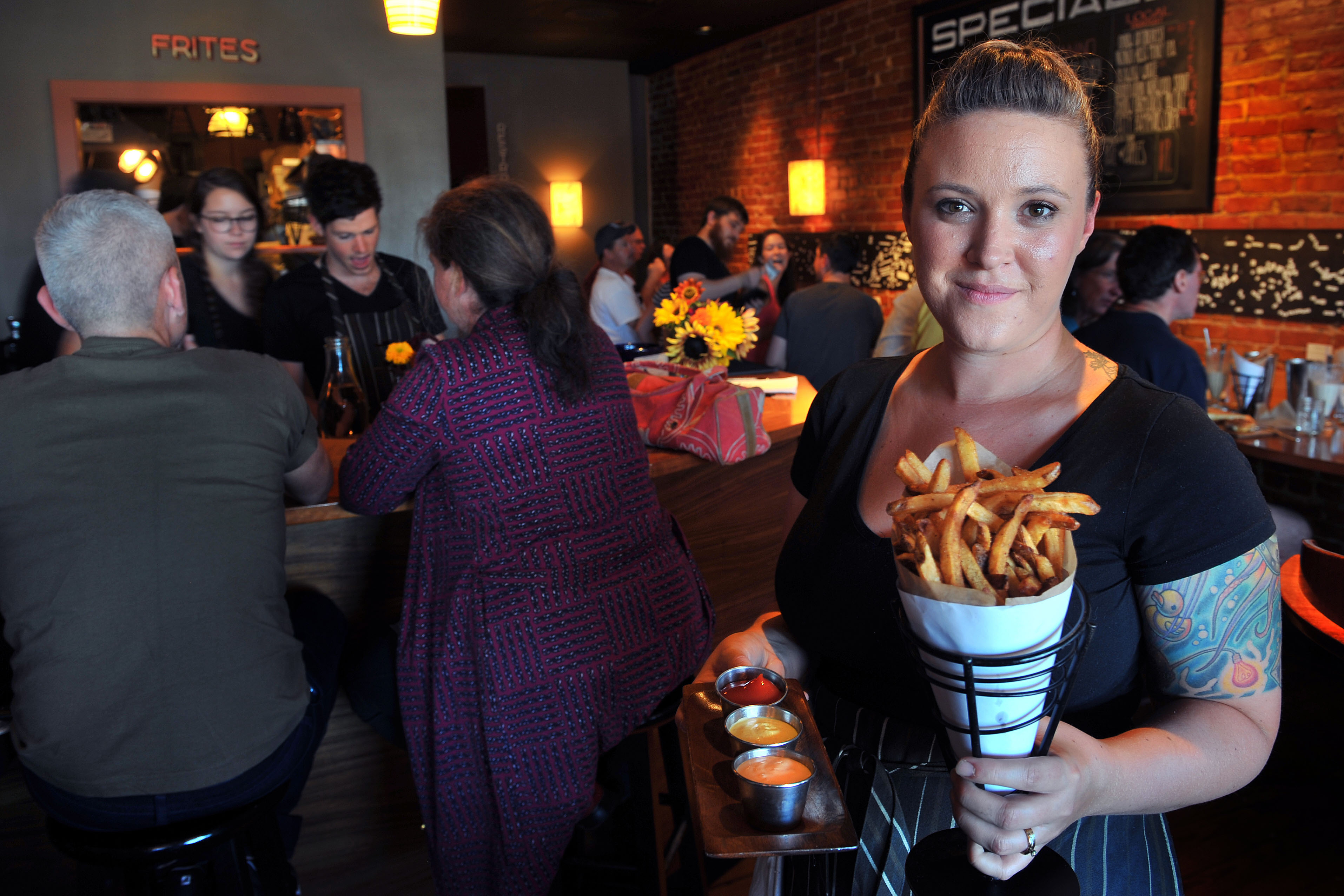 Mariah Pisha-Duffly holds the Portland restaurant's signature fries cooked in duck fat.