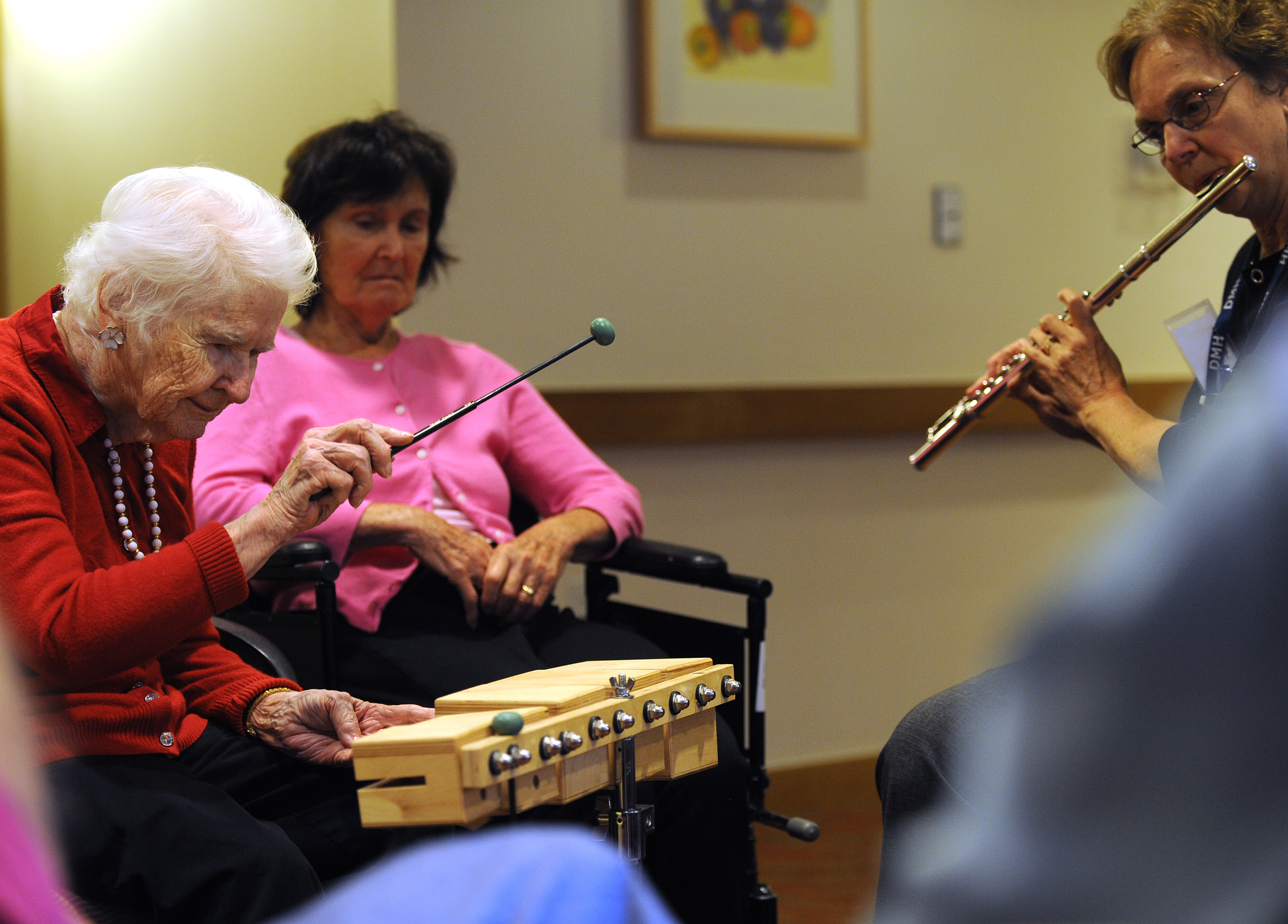 In the music class at NewBridge on the Charles, Dorothy plays percussion and therapist Sally Harrison plays the flute.