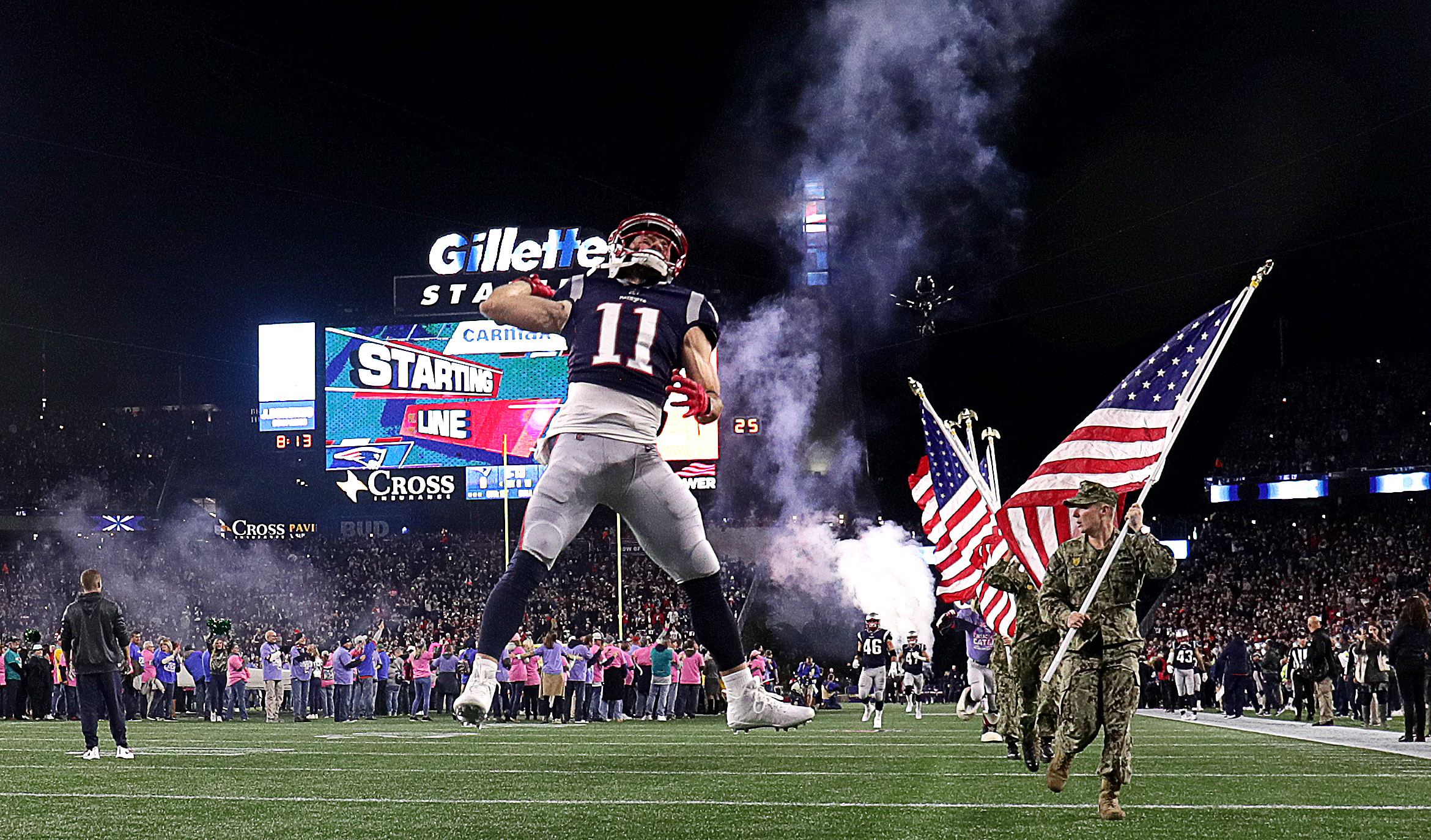 Julian Edelman (11) leaps into the air as he and his teammates take the field before kickoff. Edelman, in his second game back from suspension and an ACL tear, caught four passes for 54 yards and a touchdown.