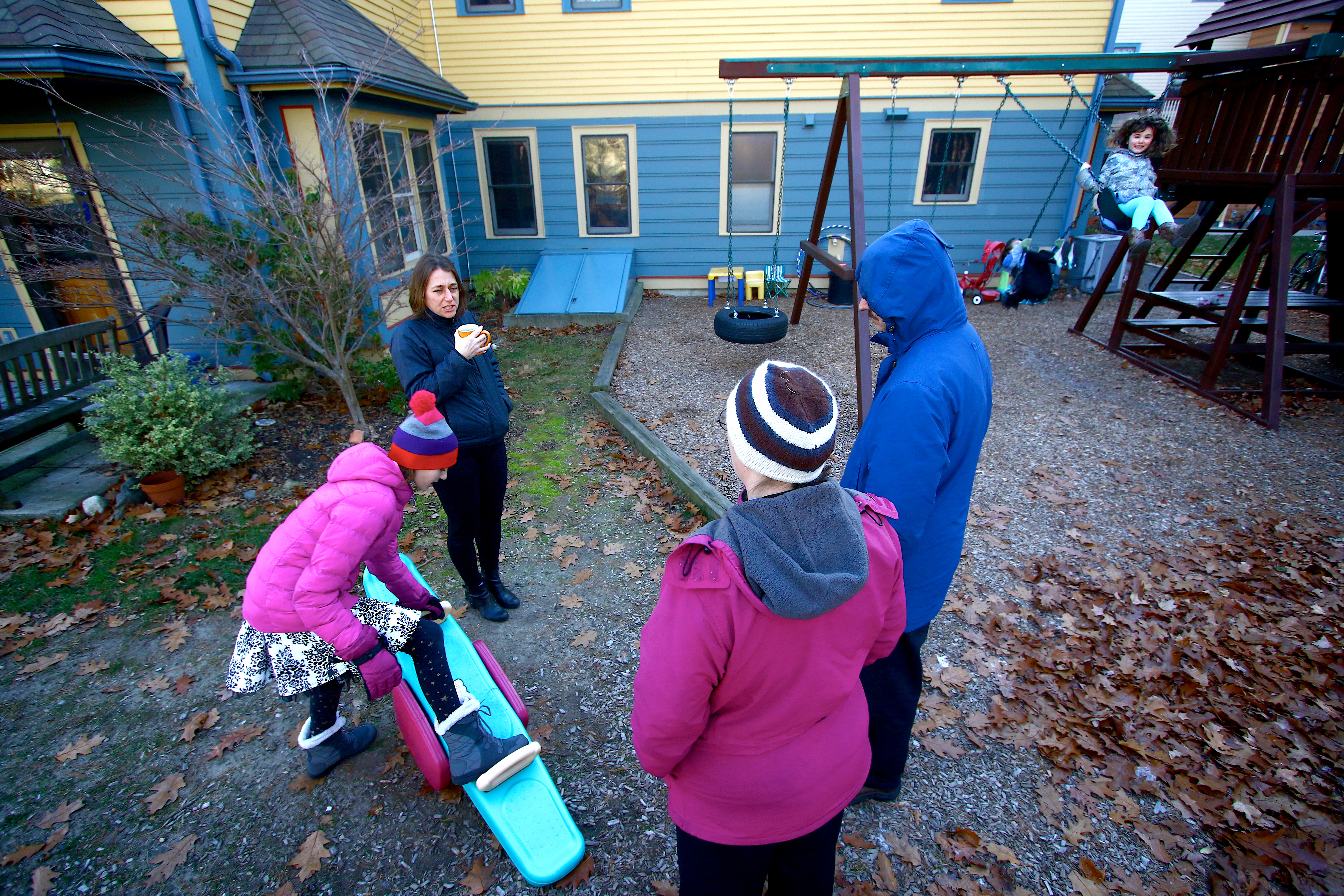 Melissa Paschall speaks with Jenise Aminoff and her husband, Alex, while their daughter, Annelise, 12, plays in a common area.