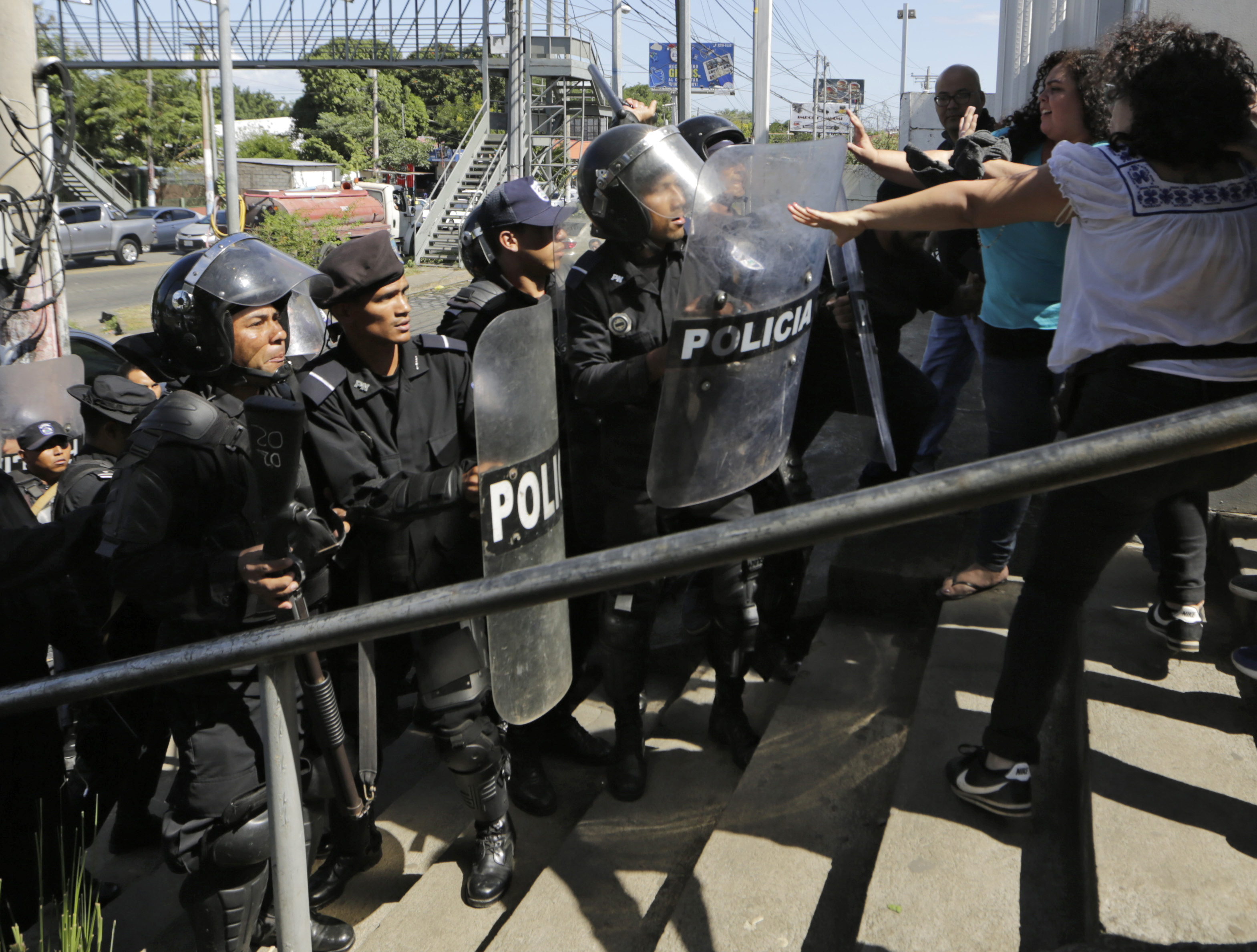 Riot police confront journalists in Managua, amid a crackdown on media and human-rights organizations