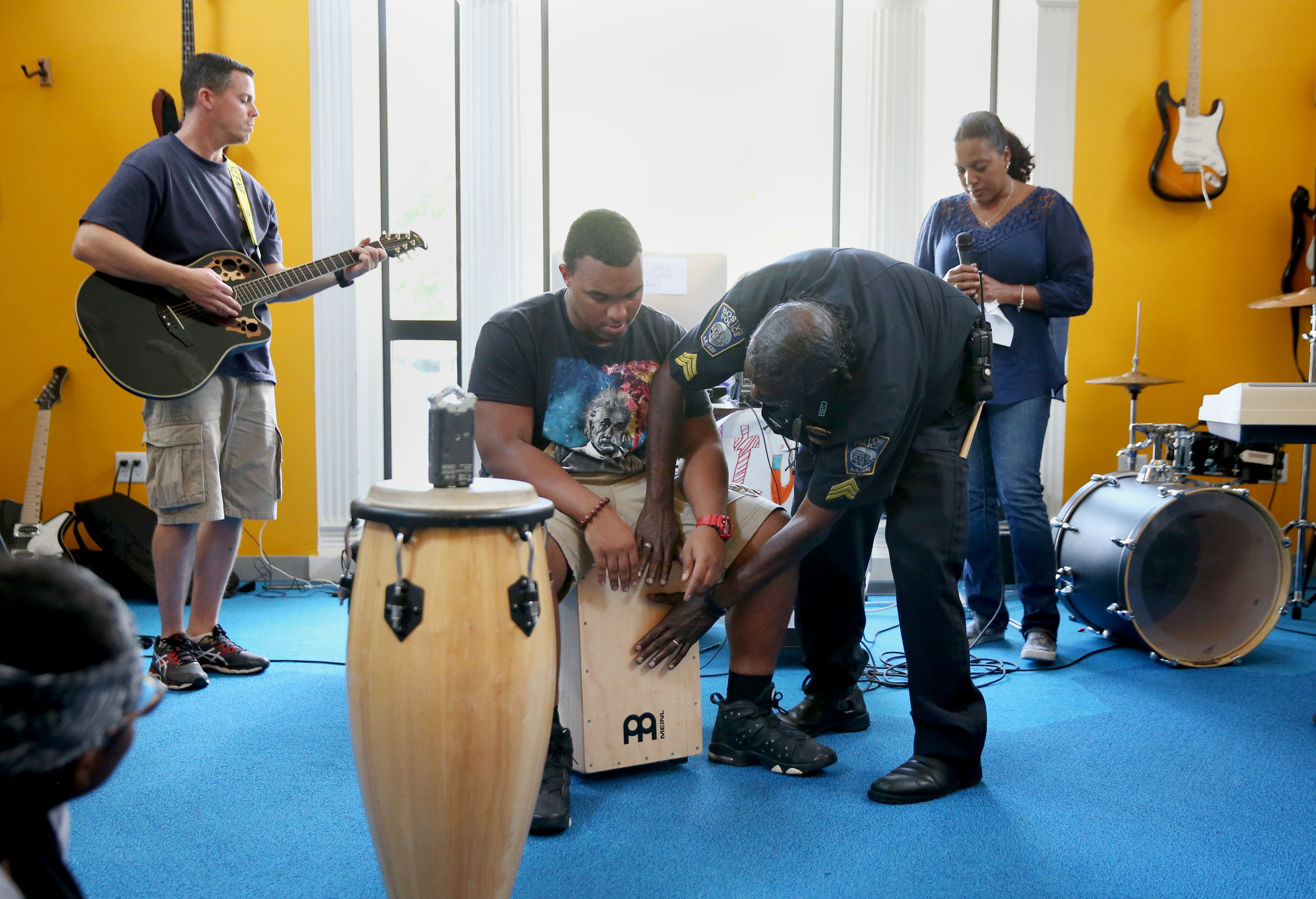 Center: Carlos Barbosa, 17, of Dorchester, and Boston Police Department Sergeant John Burns come up with a beat during a Code Listen musical session.