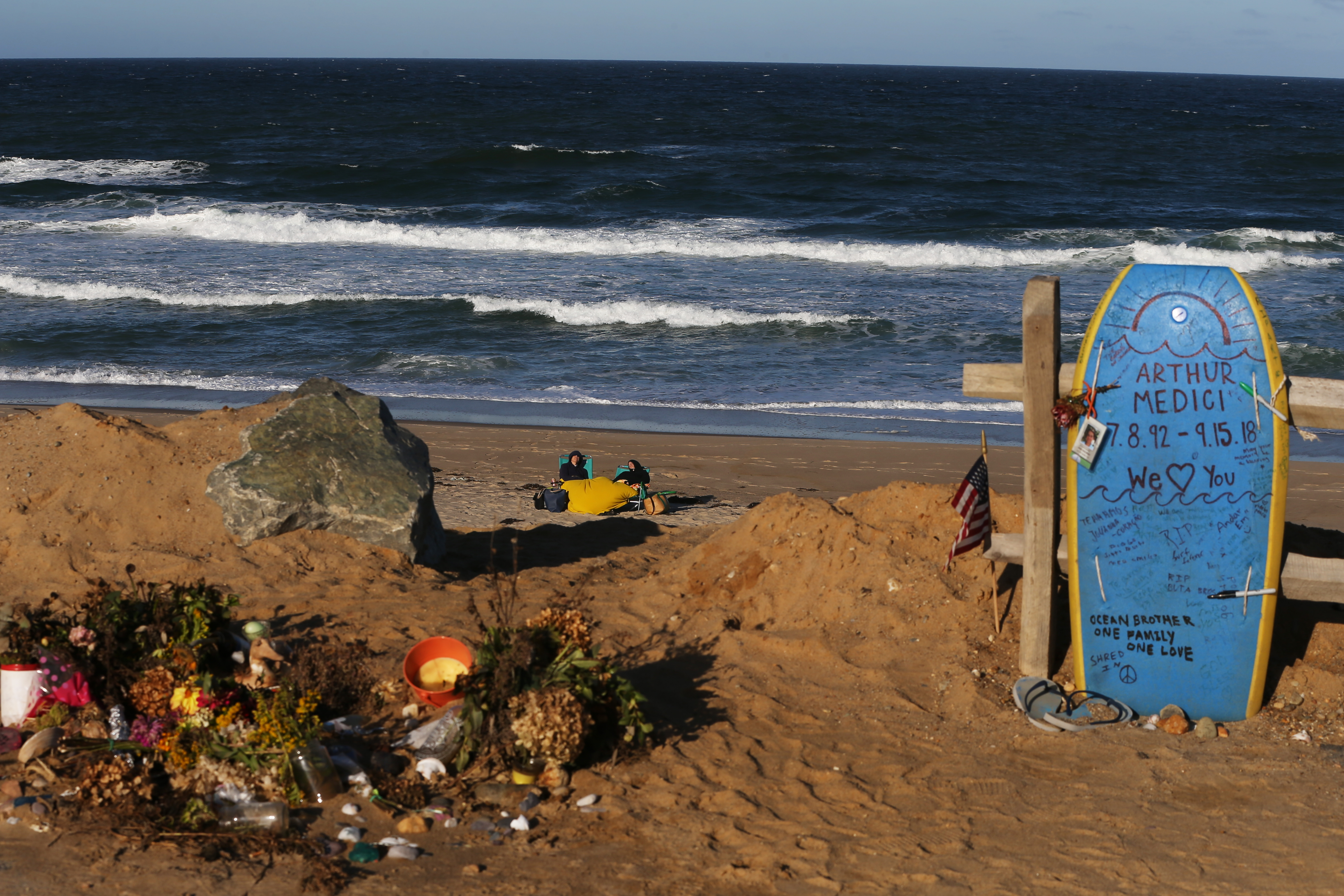 Beachgoers passed by Arthur Medici’s memorial on Newcomb Hollow Beach on Thursday.