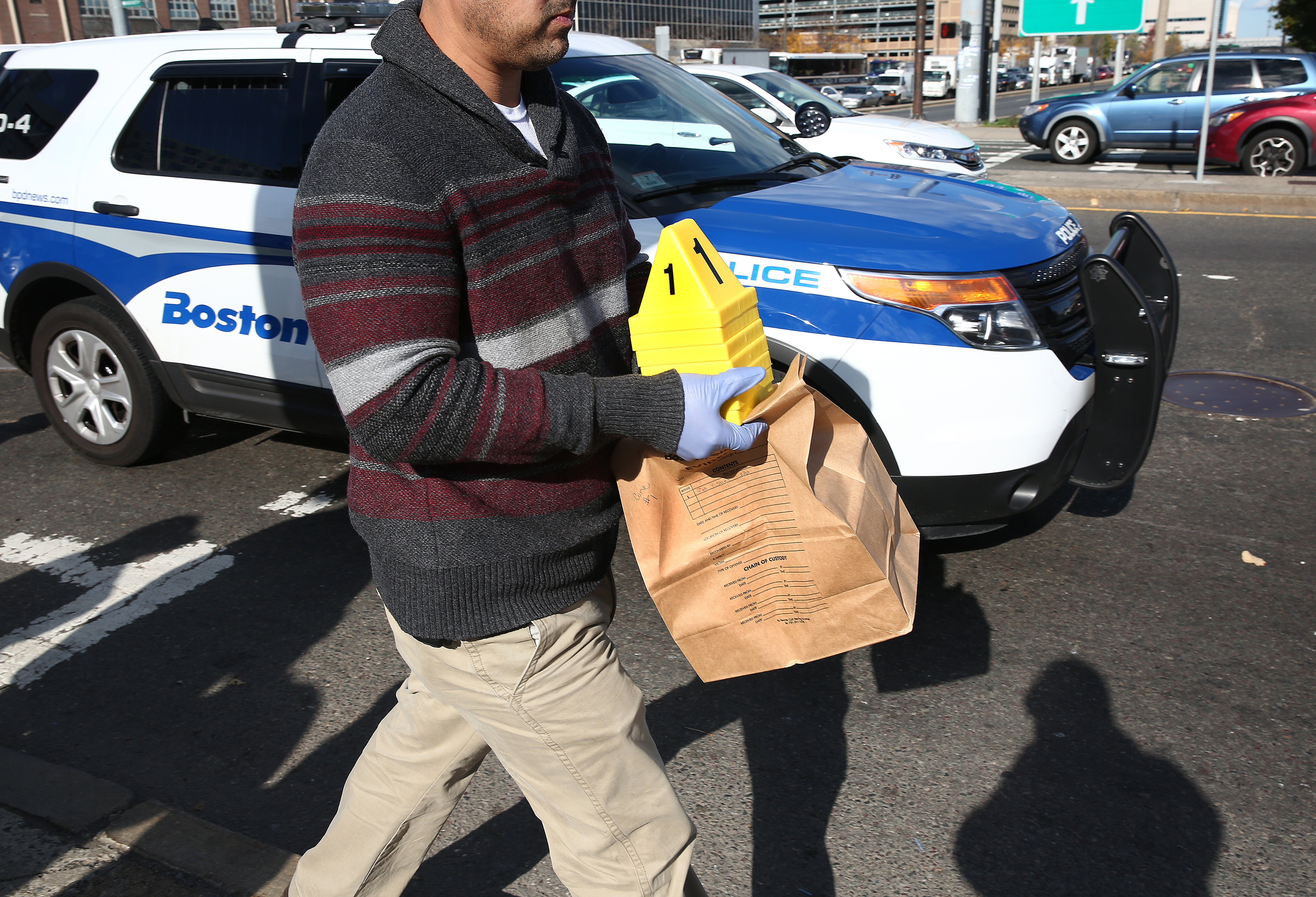 A Boston police detective carried an evidence bag from the scene.