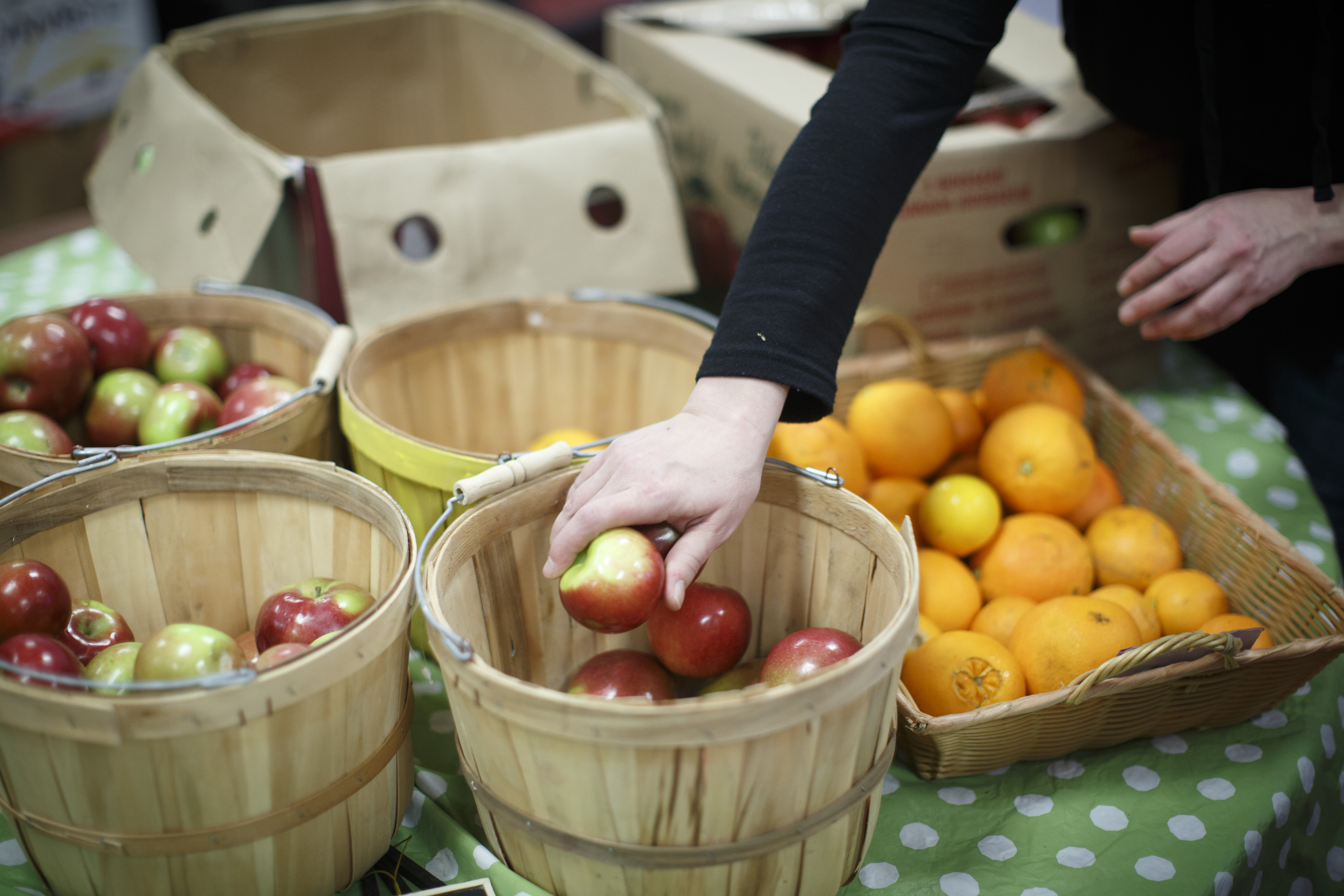 A volunteer set out fresh fruit during the “farmers market.”