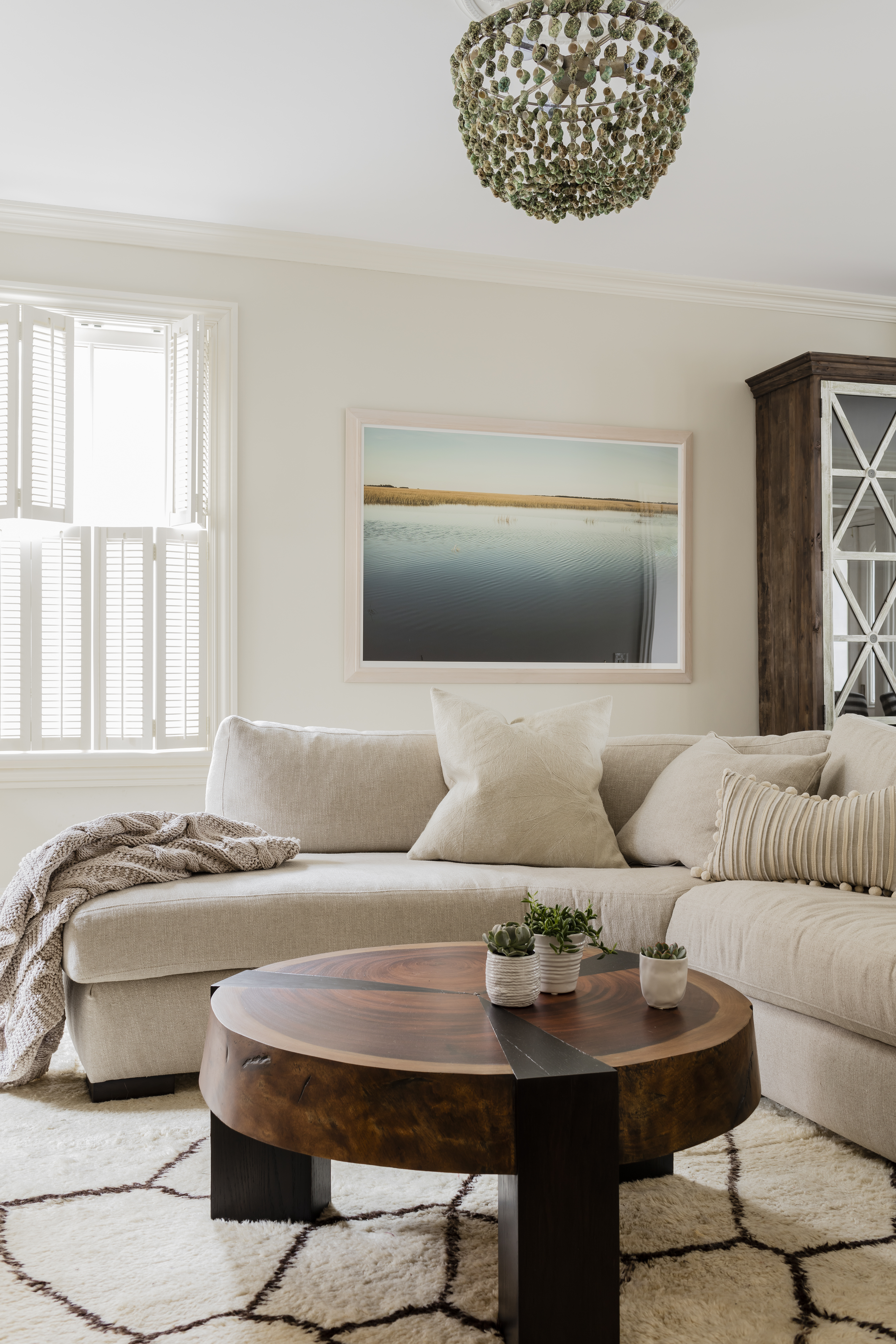 A coastal photograph in the living room appeals to Jill’s love of the outdoors; the round wood coffee table is both handsome and practical with a baby crawling about.