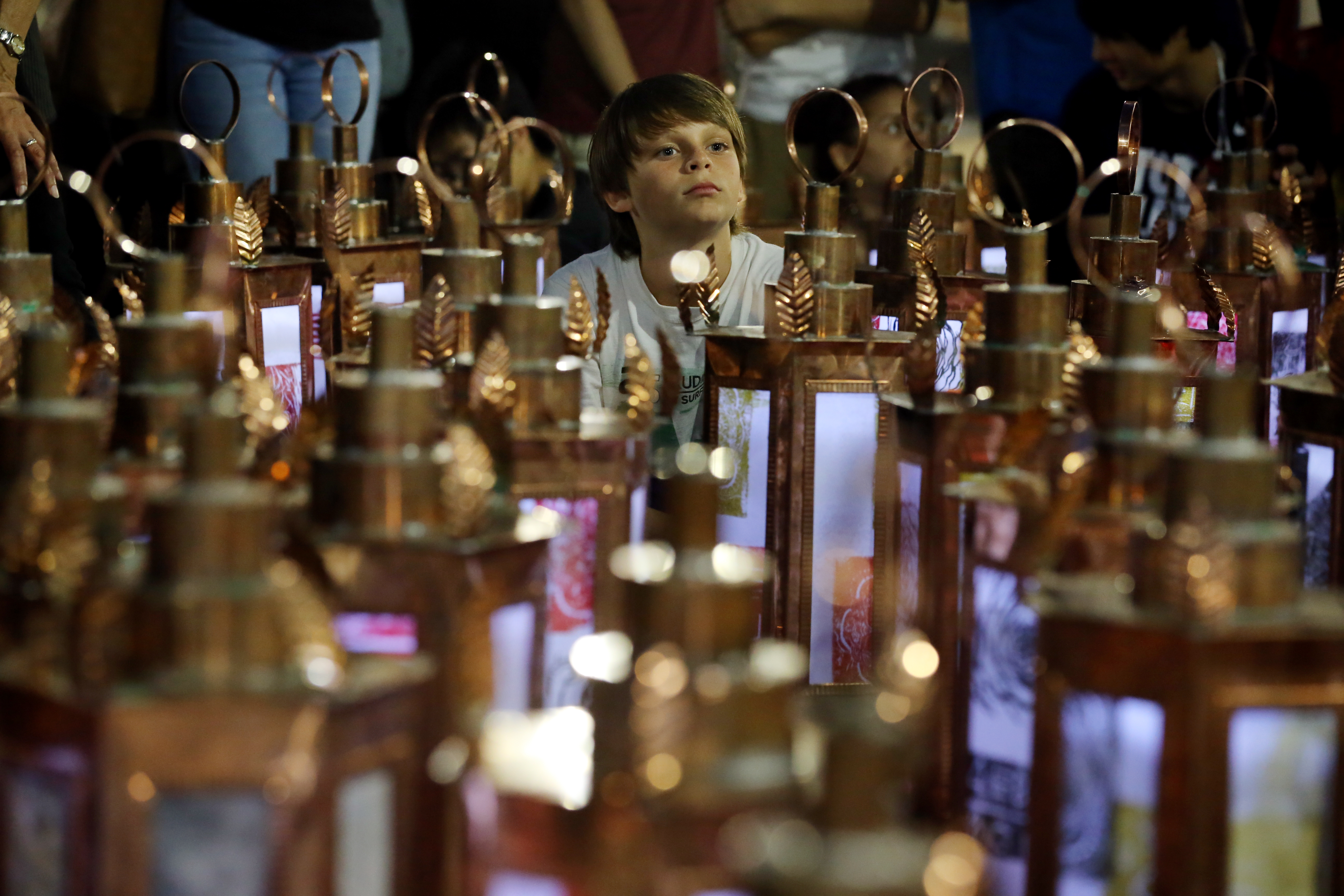 Ben Sutton, 10, sat among the lanterns at the commemorative ceremony at Liberty Tree Plaza in Boston on Friday.