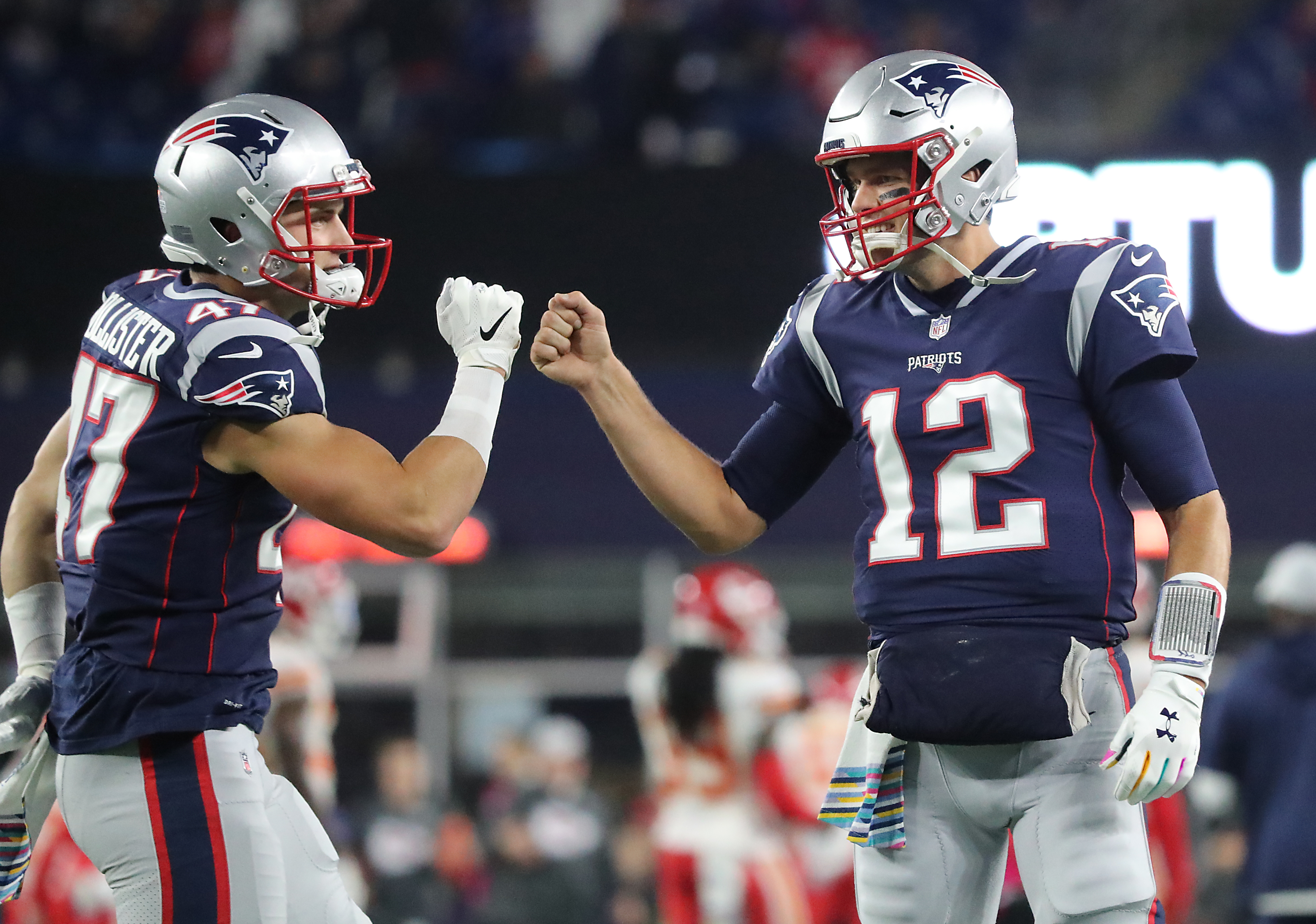 Tom Brady fist bumps teammate tight end Jacob Hollister.