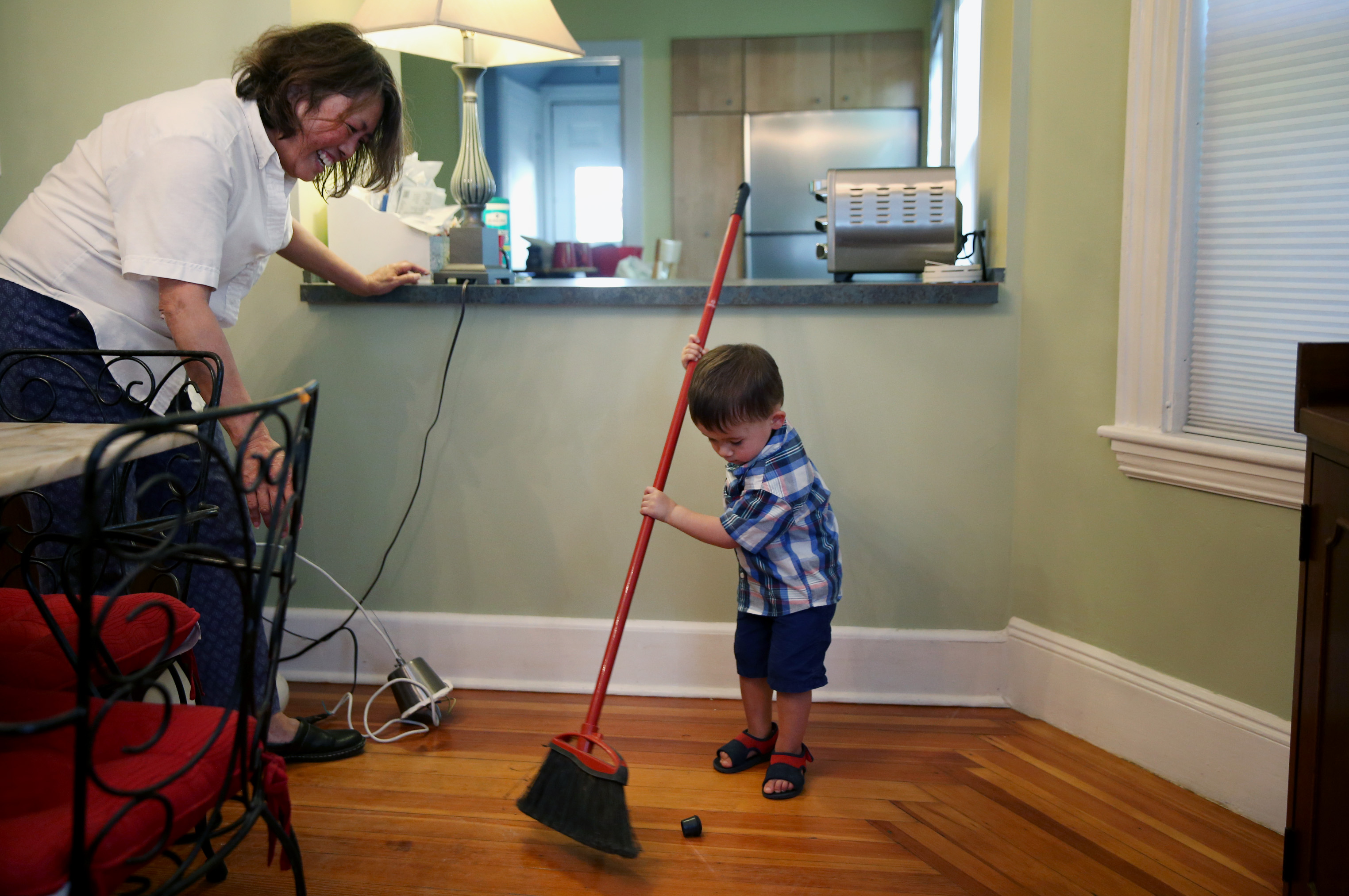 James sweeps his grandmother’s dining room. Euler lives on the first floor, and her daughter’s family is on the second and third.