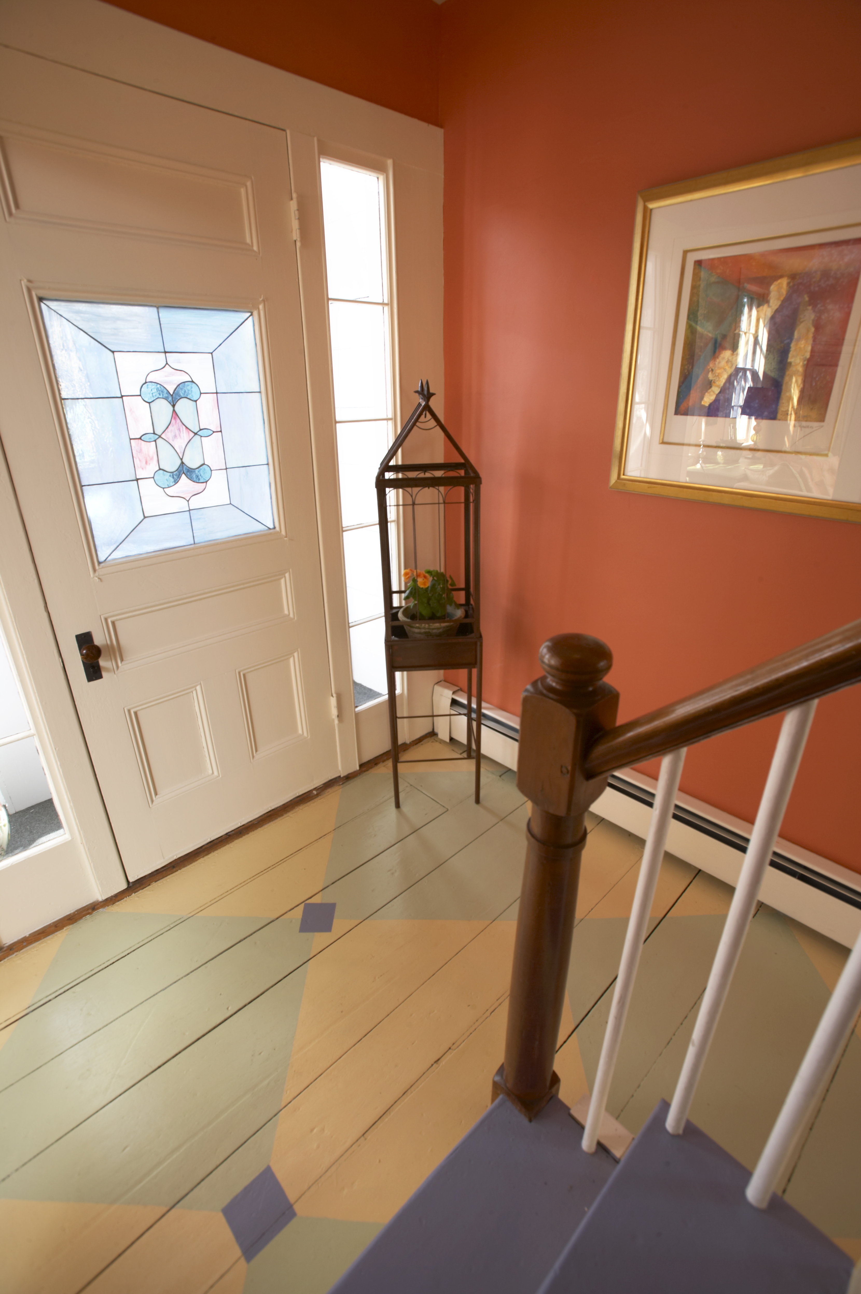 This entryway by designer Lisa Teague of New Hampshire has a simple harlequin pattern with medallion squares to bring in a third color.