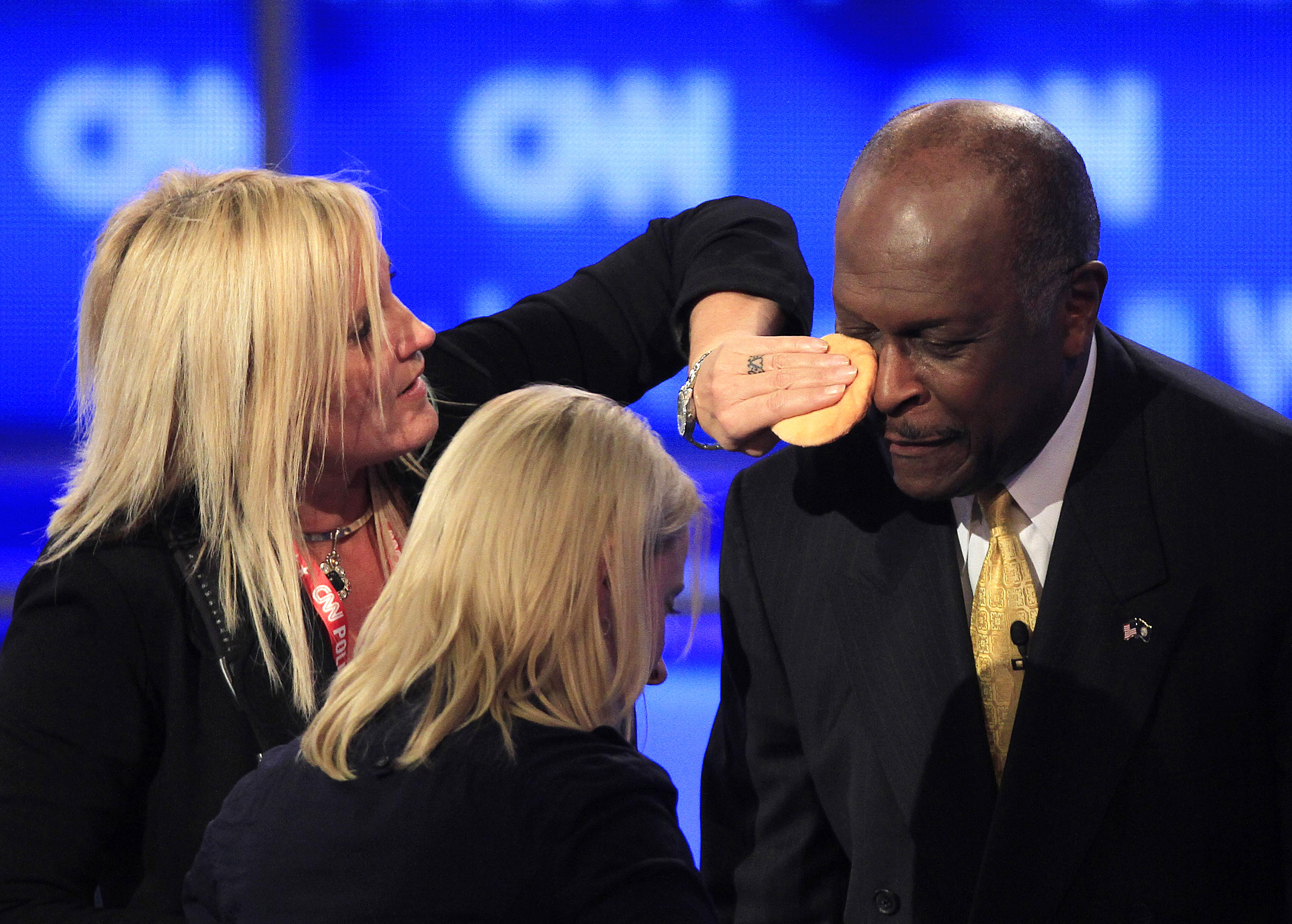 Kriss Blevens blotted Herman Cain with powder during a break in the first televised Republican presidential debate of 2011 at Saint Anselm College in Manchester, N.H.