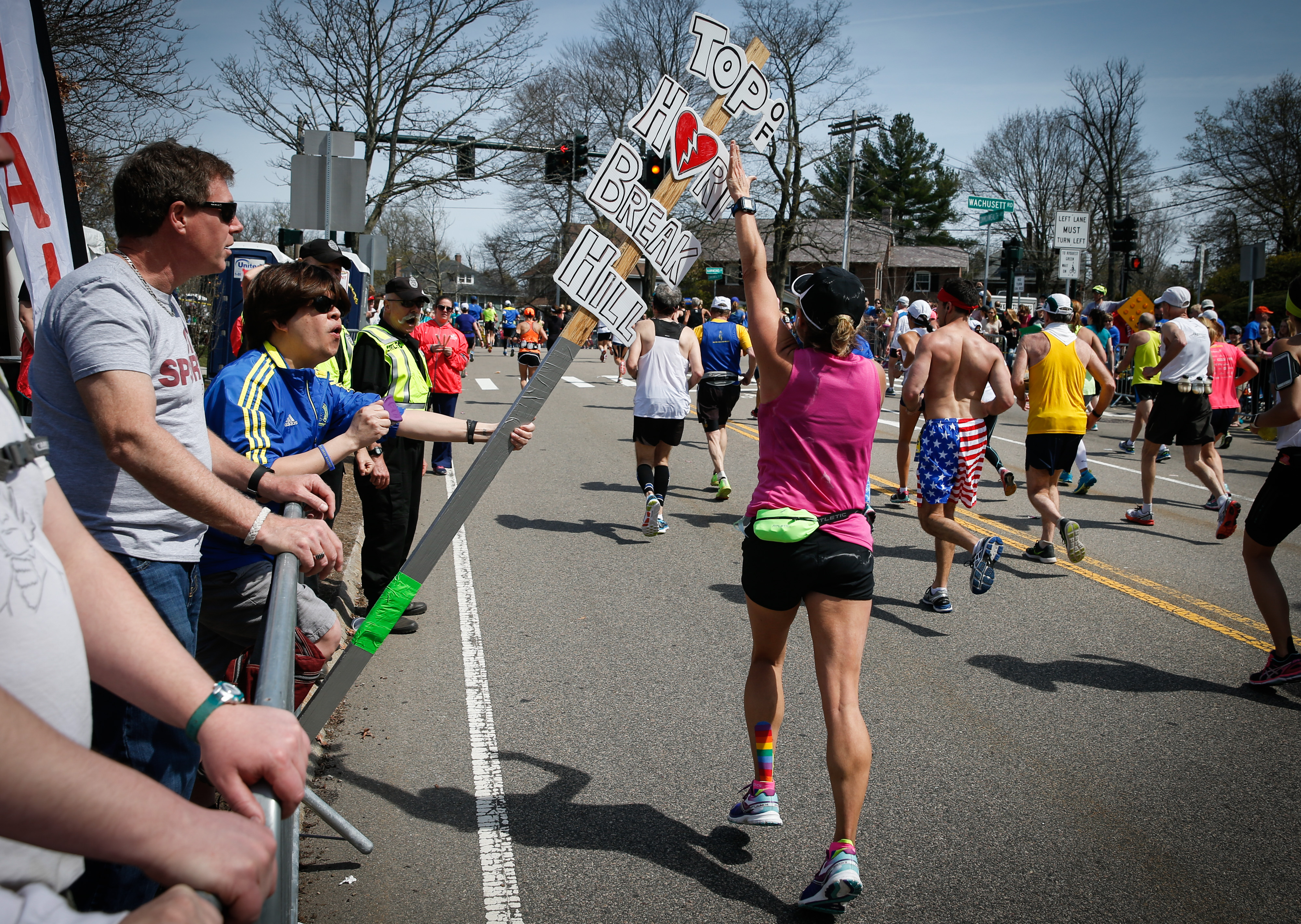 A runner tapped a sign to celebrate climbing "Heartbreak Hill" during the running of the 120th Boston Marathon in Newton on April 18, 2016.