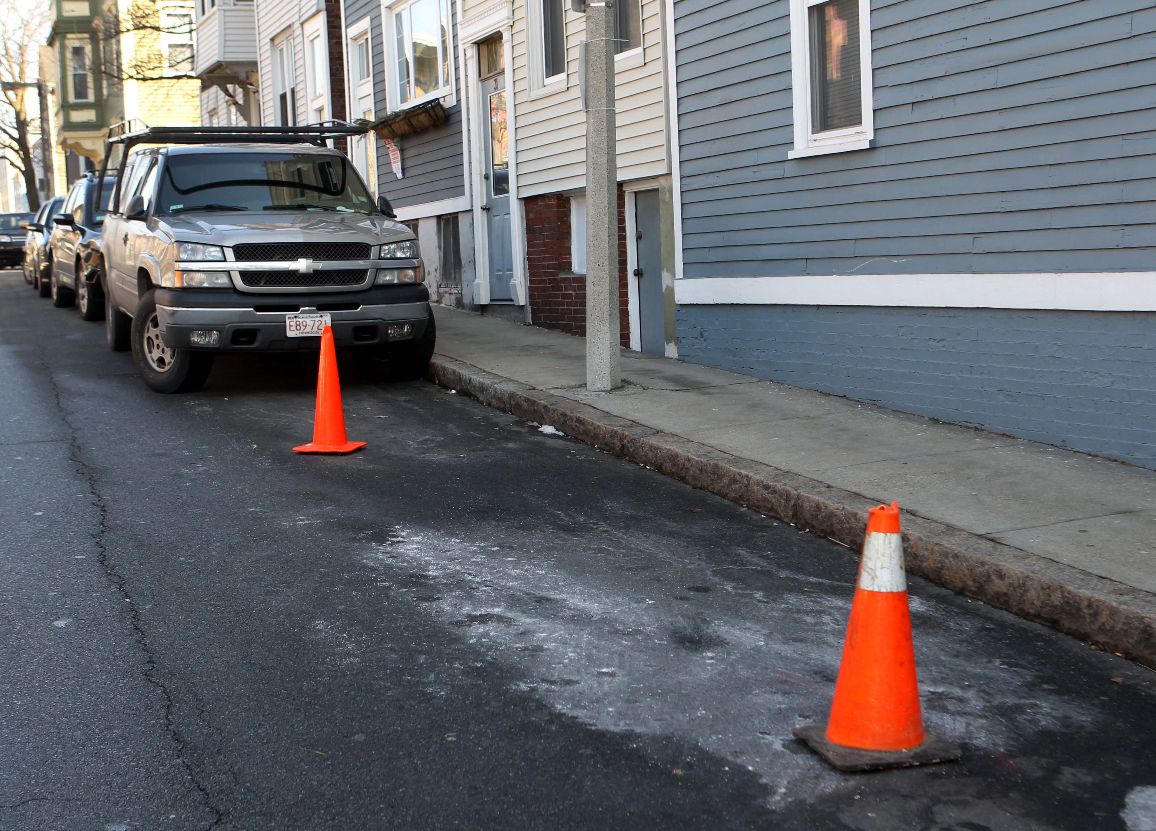 The snow was gone on School Street in Charlestown, but cones used as space savers stayed.