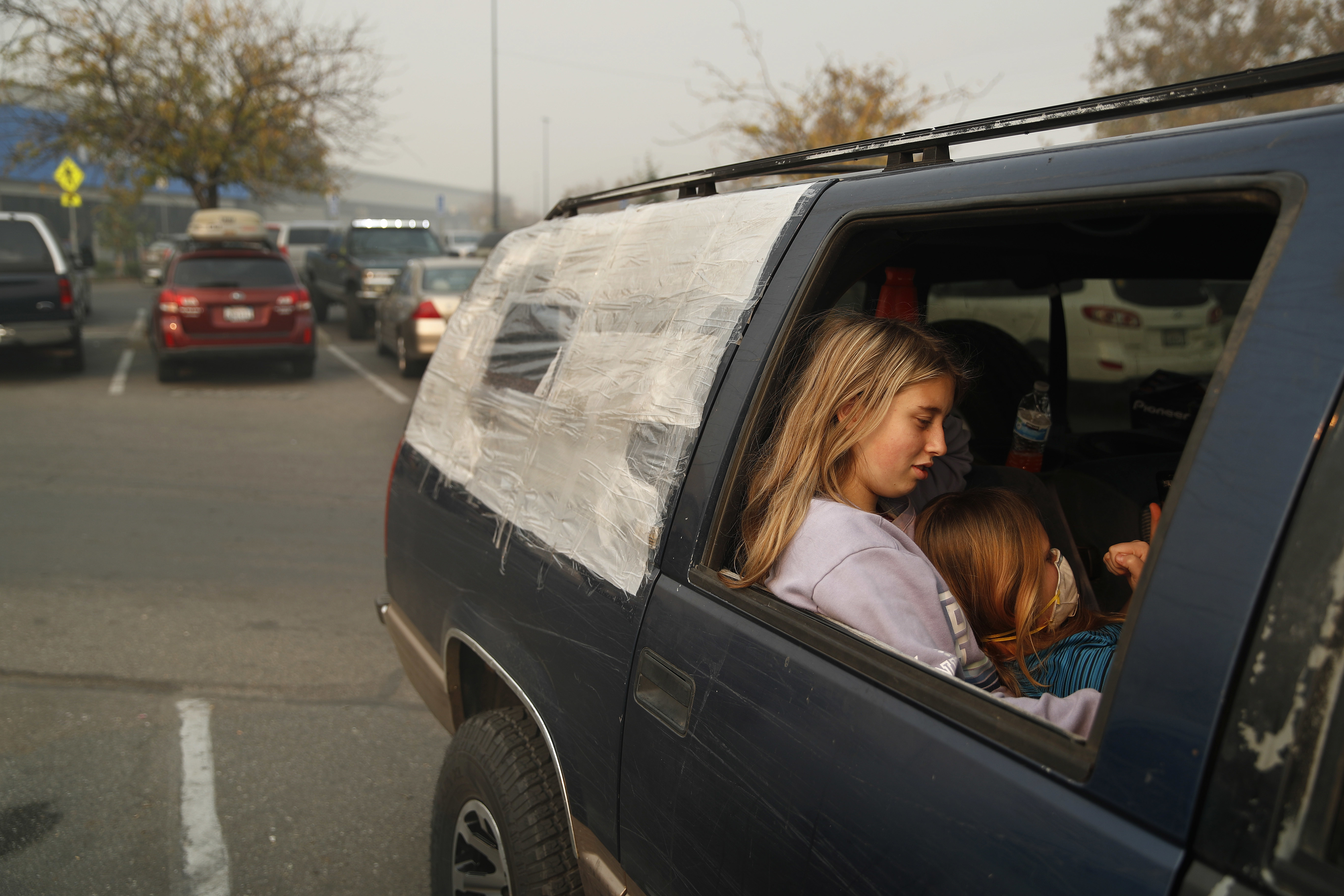 Displaced people rested in a truck, part of an encampment outside a Walmart in Chico.