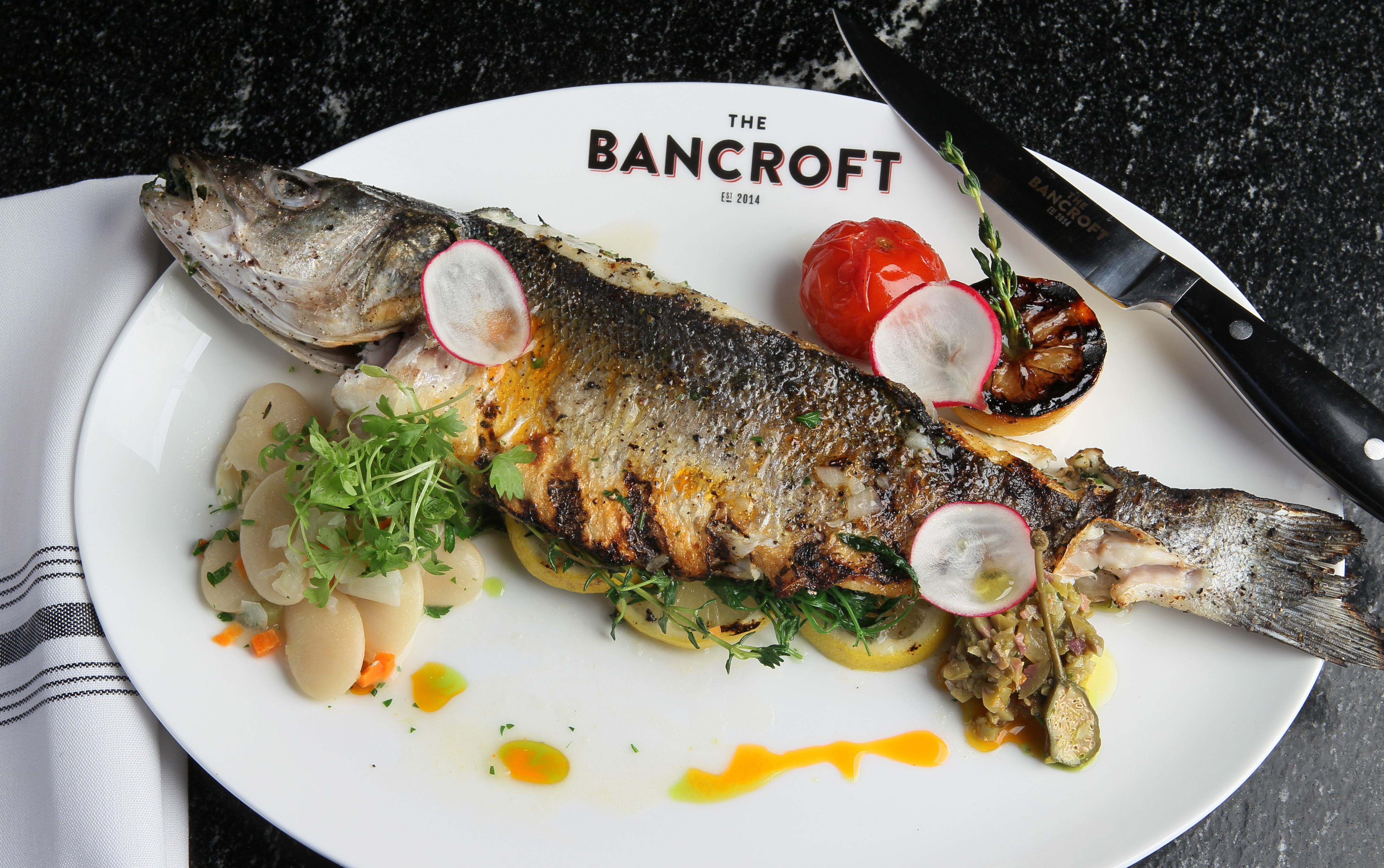 Whole grilled branzino with green olive and caper relish.
