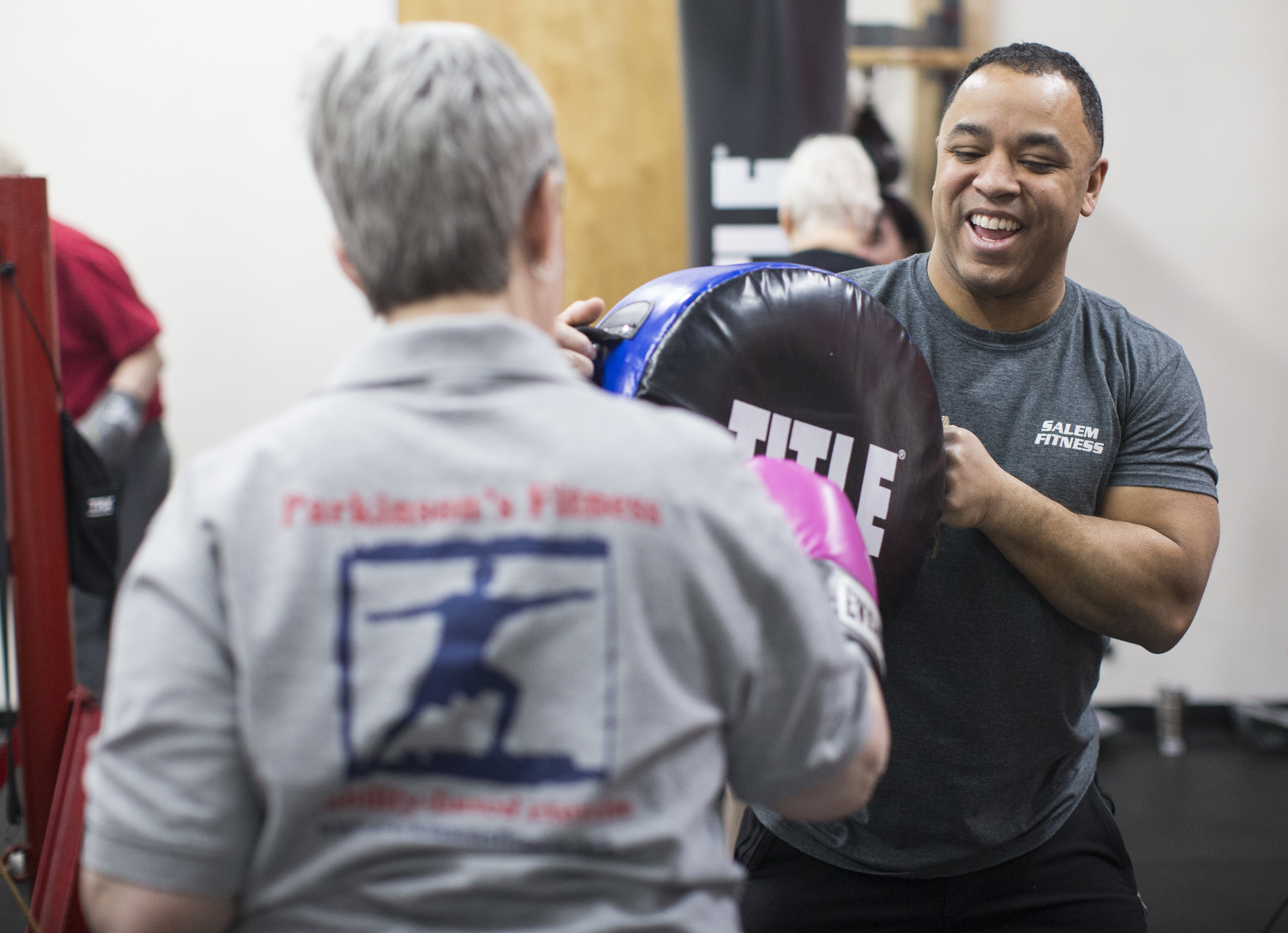 Michael Reyes (right) does a drill with Laurie Grieves at the Salem Fitness Center.