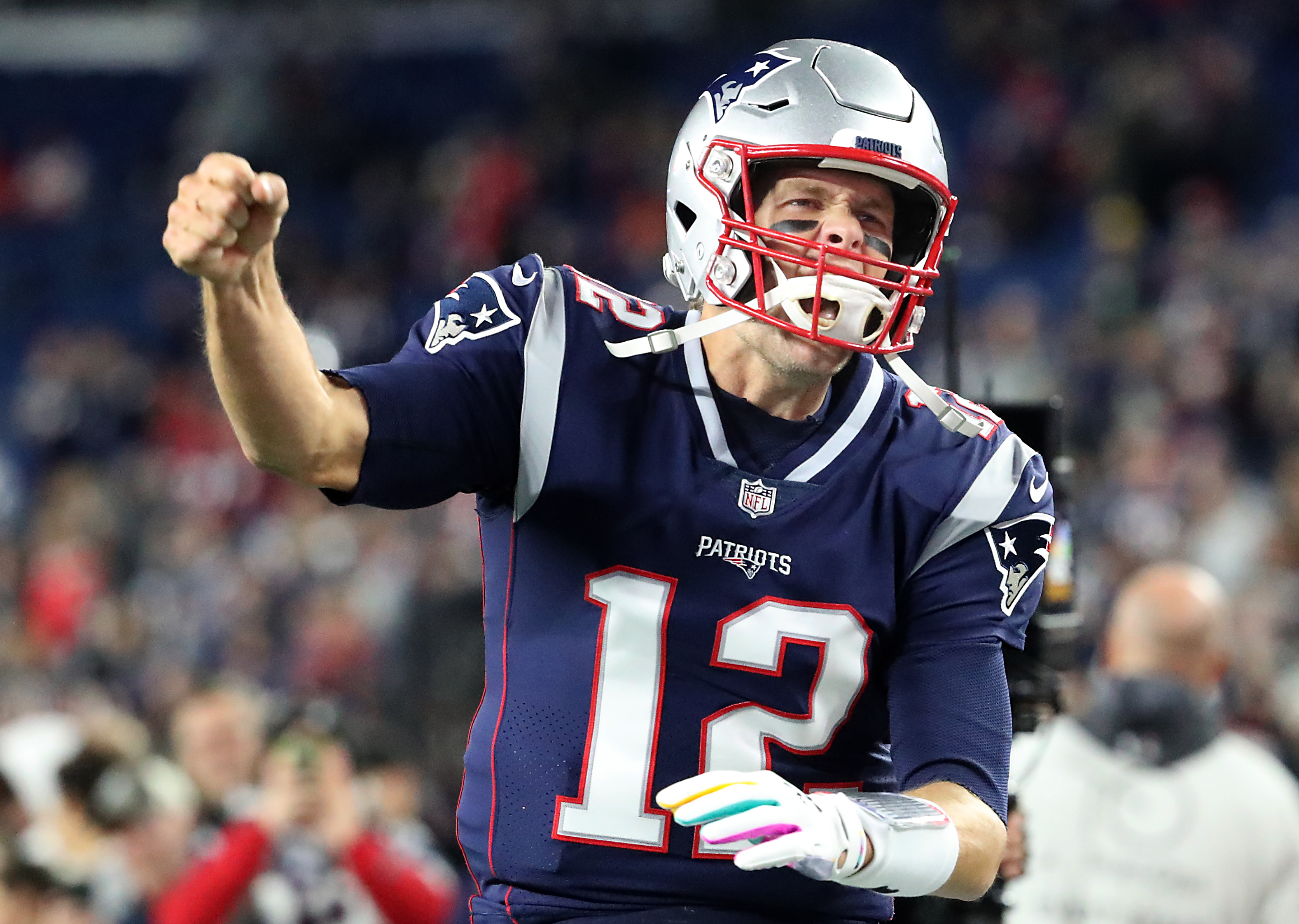 Tom Brady pumps his fist after running onto the field.
