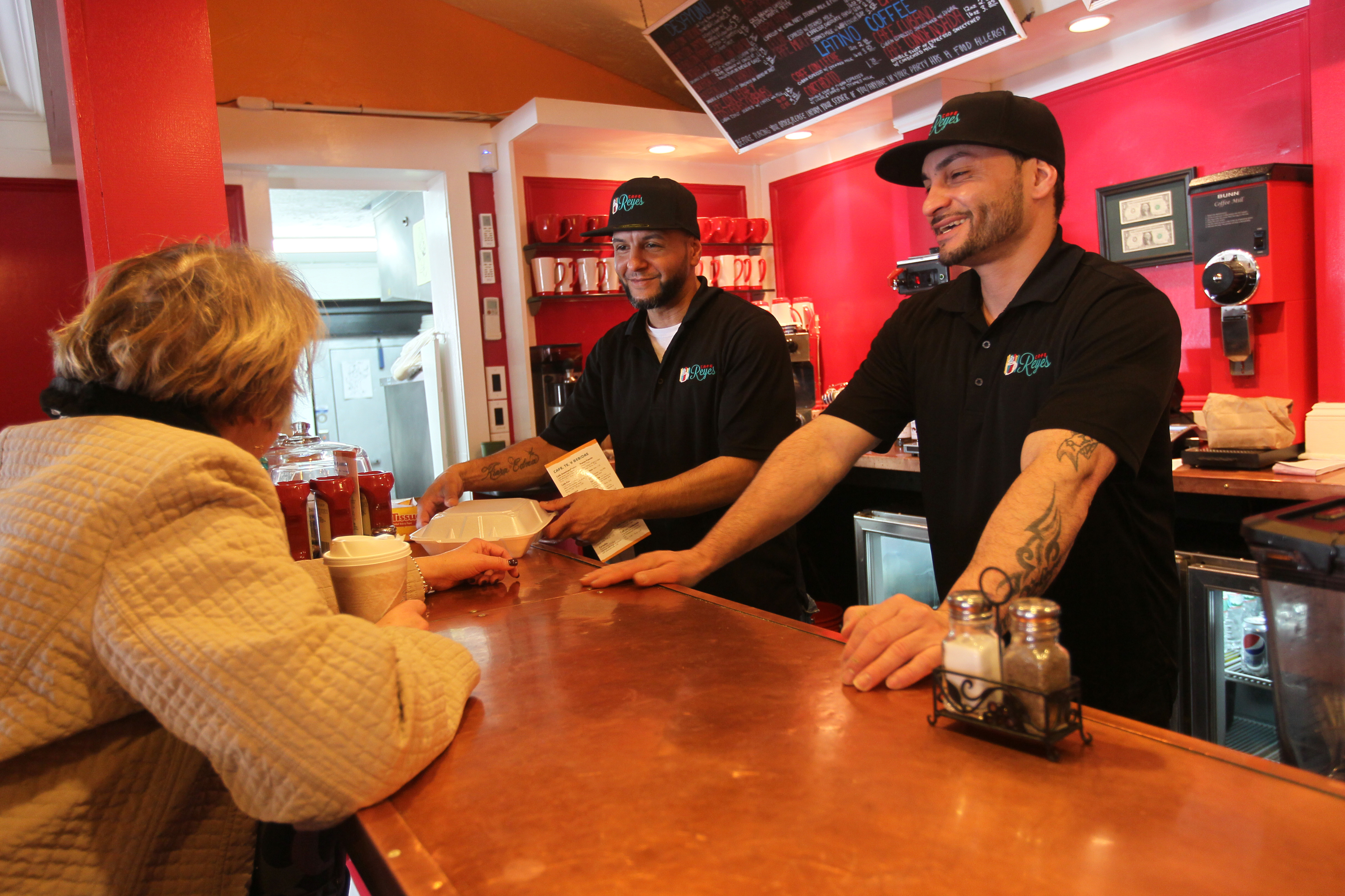 Jesus Rivera (center) and Carlos Echevarria waited on Phyllis DiFronzo of Worcester at Cafe Reyes earlier this month.