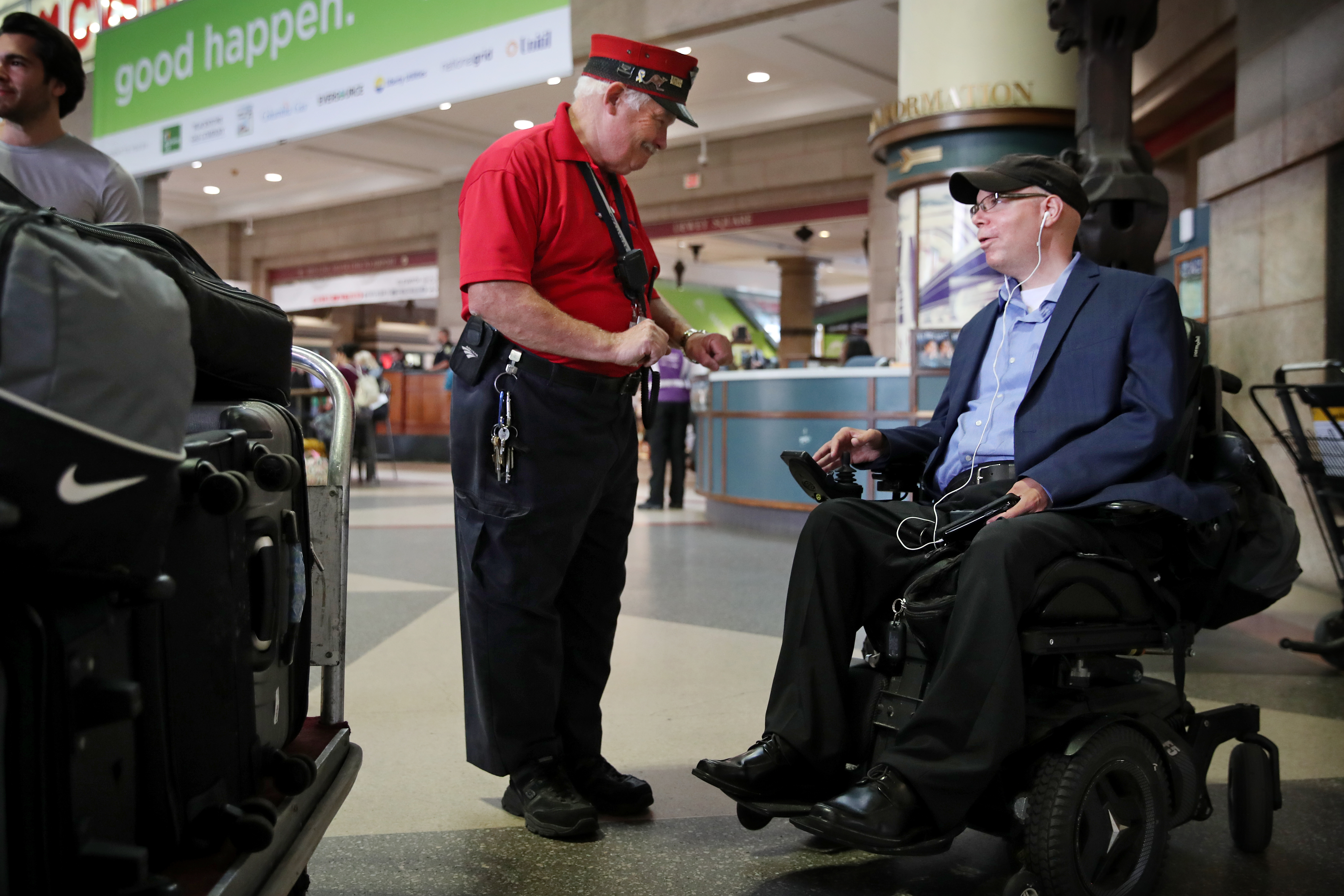 Amtrak Red Cap Frank Keenan (center) spoke with traveler Chris Rosa, who was heading home to Queens, N.Y.