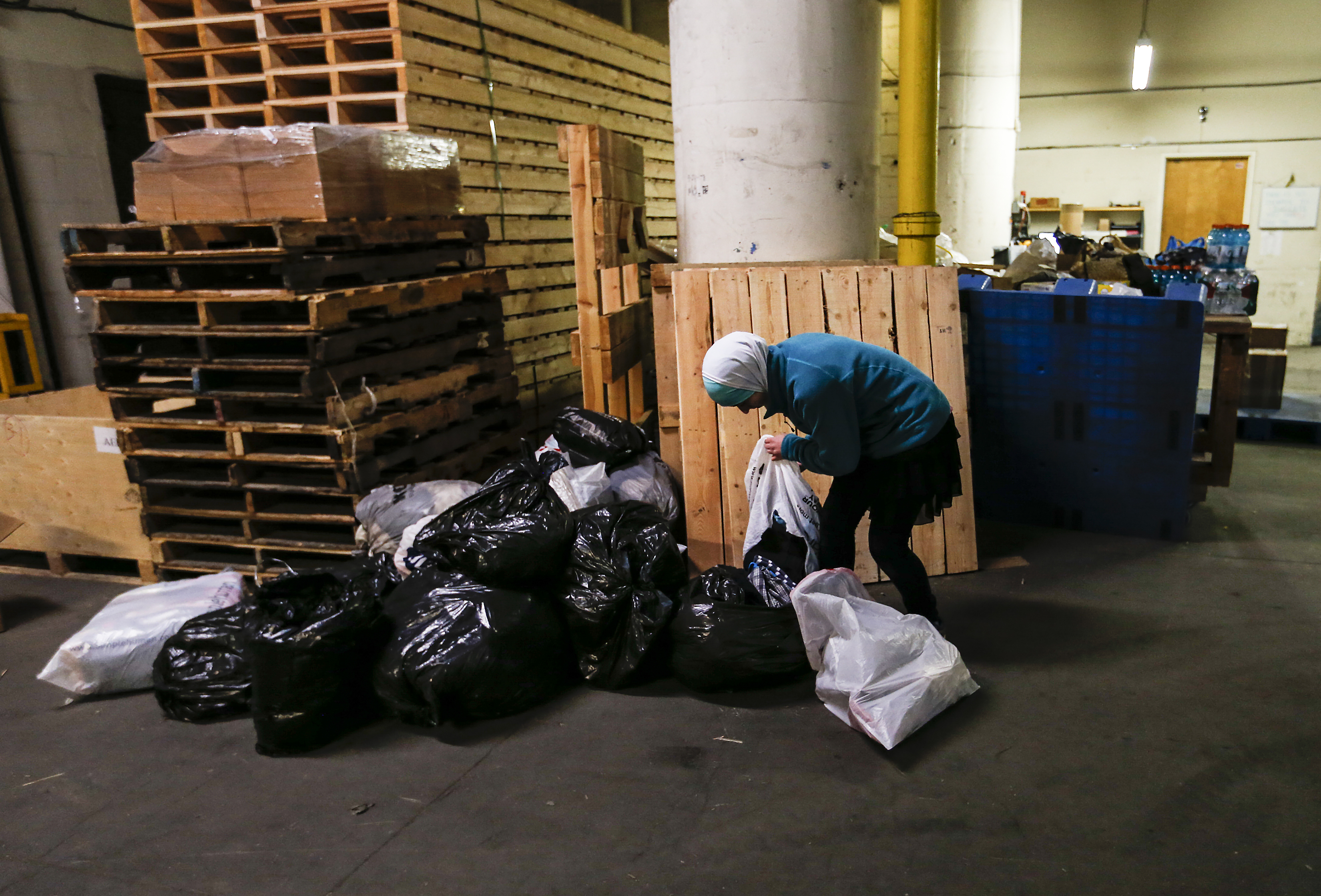 Silla Alawa, 14, separated donated clothes for her mother at a Chestnut Street storage facility.