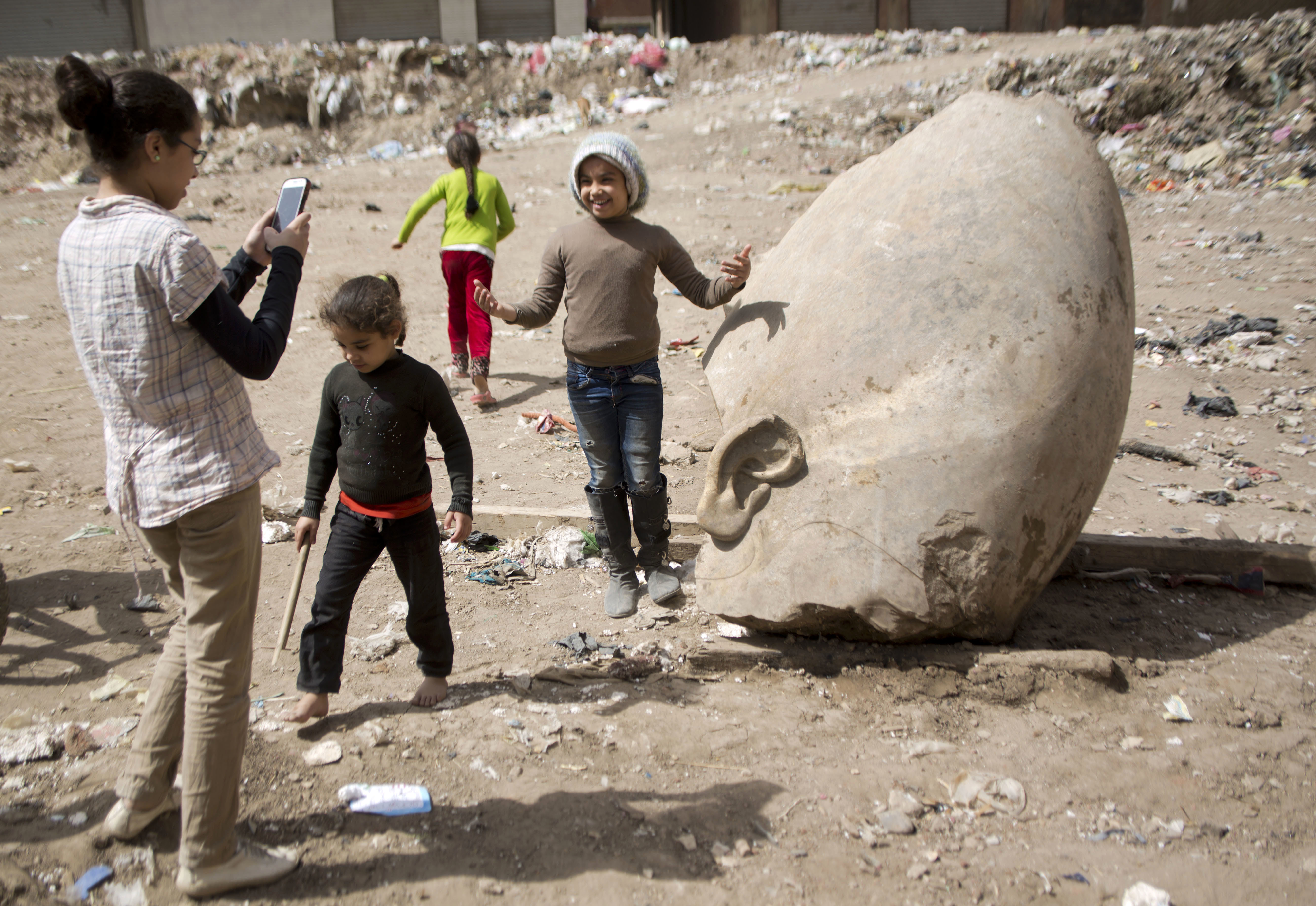 A child posed for a picture with the statue’s head.