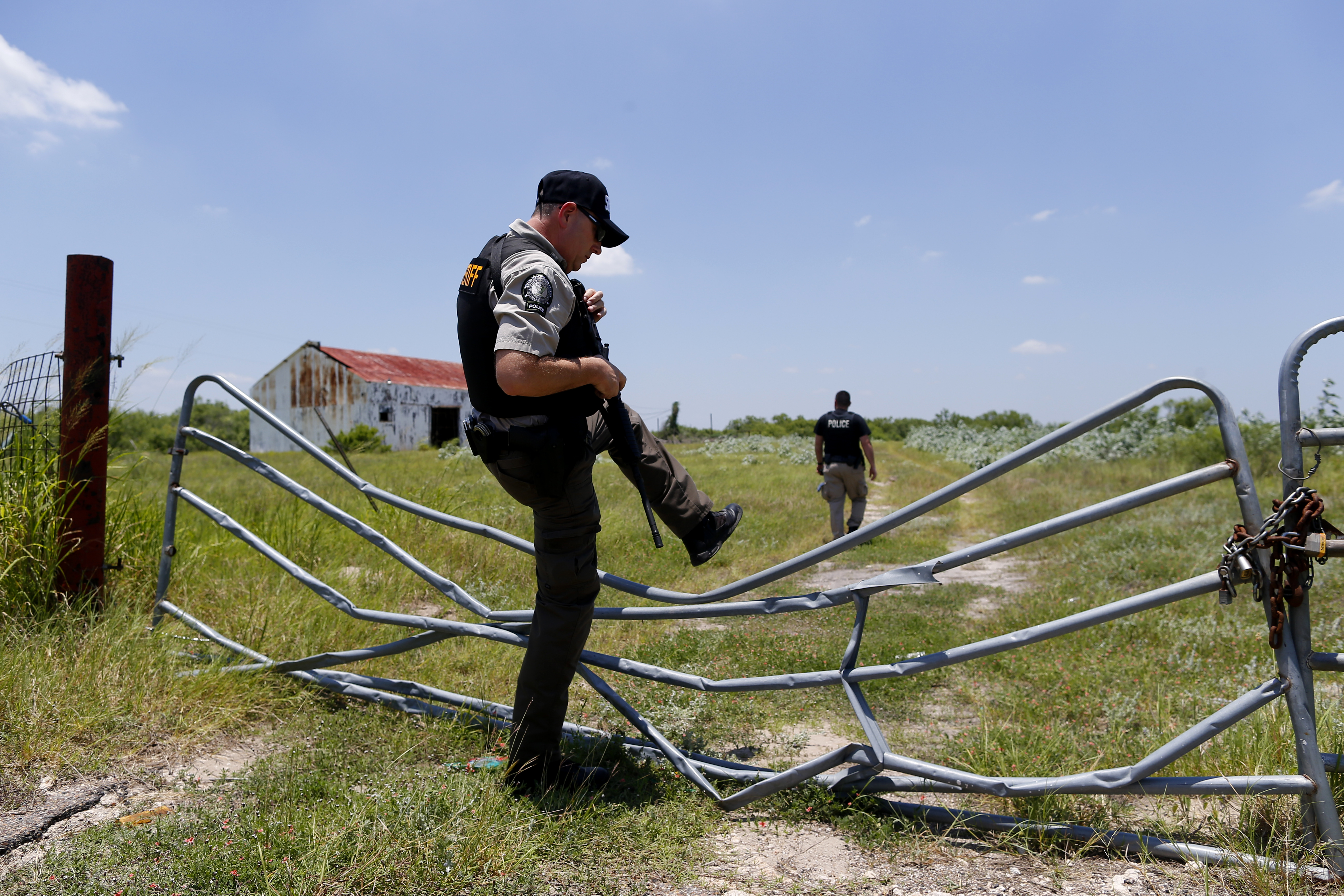 Daniel Walden (left) and Cameron Coleman, volunteer deputies for the Brooks County Sheriff’s Department, walked toward a building where migrants often stayed as they made their trek through Texas. Both officers are part of a “rescue posse” seeking to help overwhelmed local sheriffs.