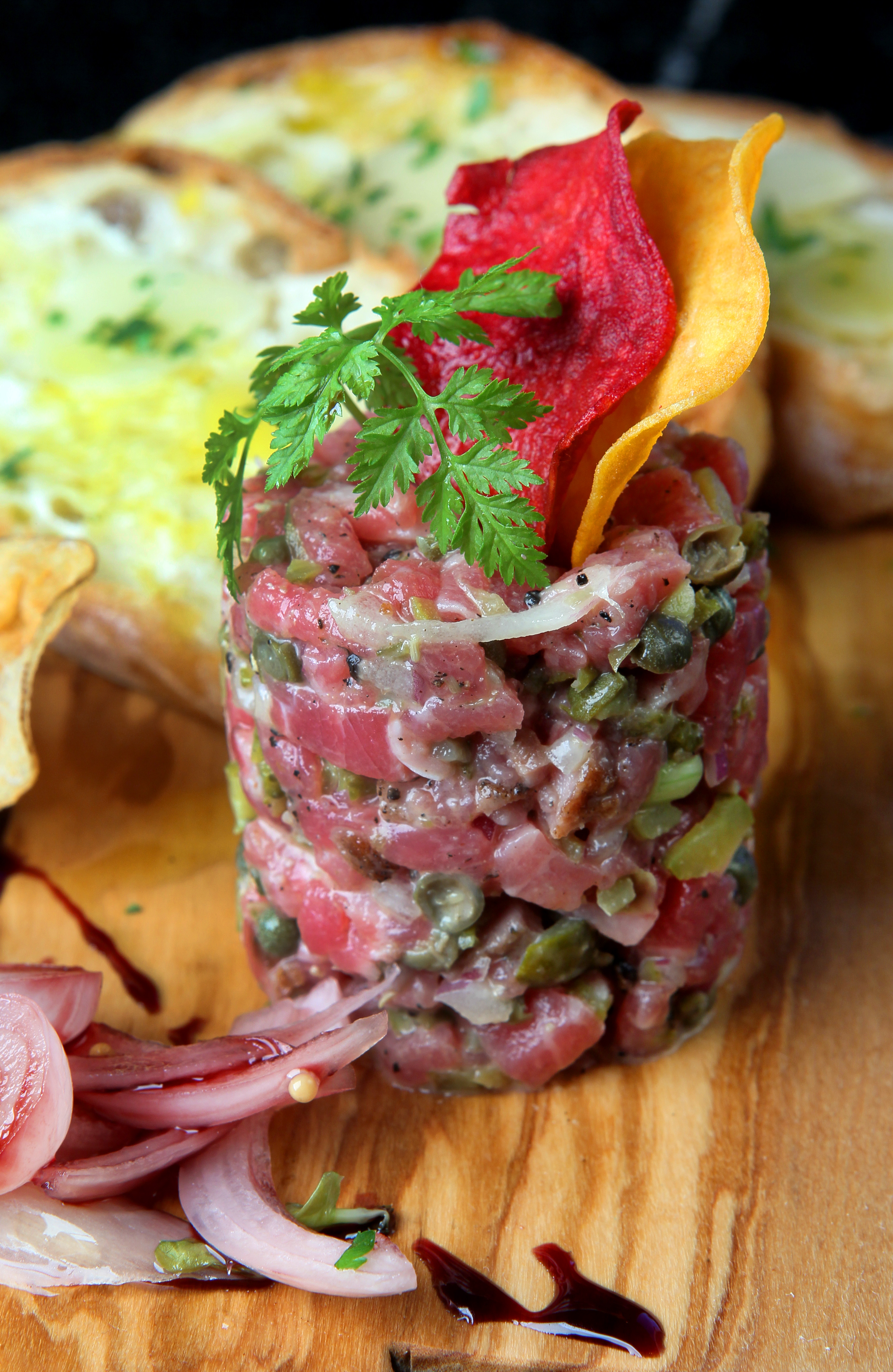 Steak tartare, with quail egg, pickled shallots, and violet mustard.