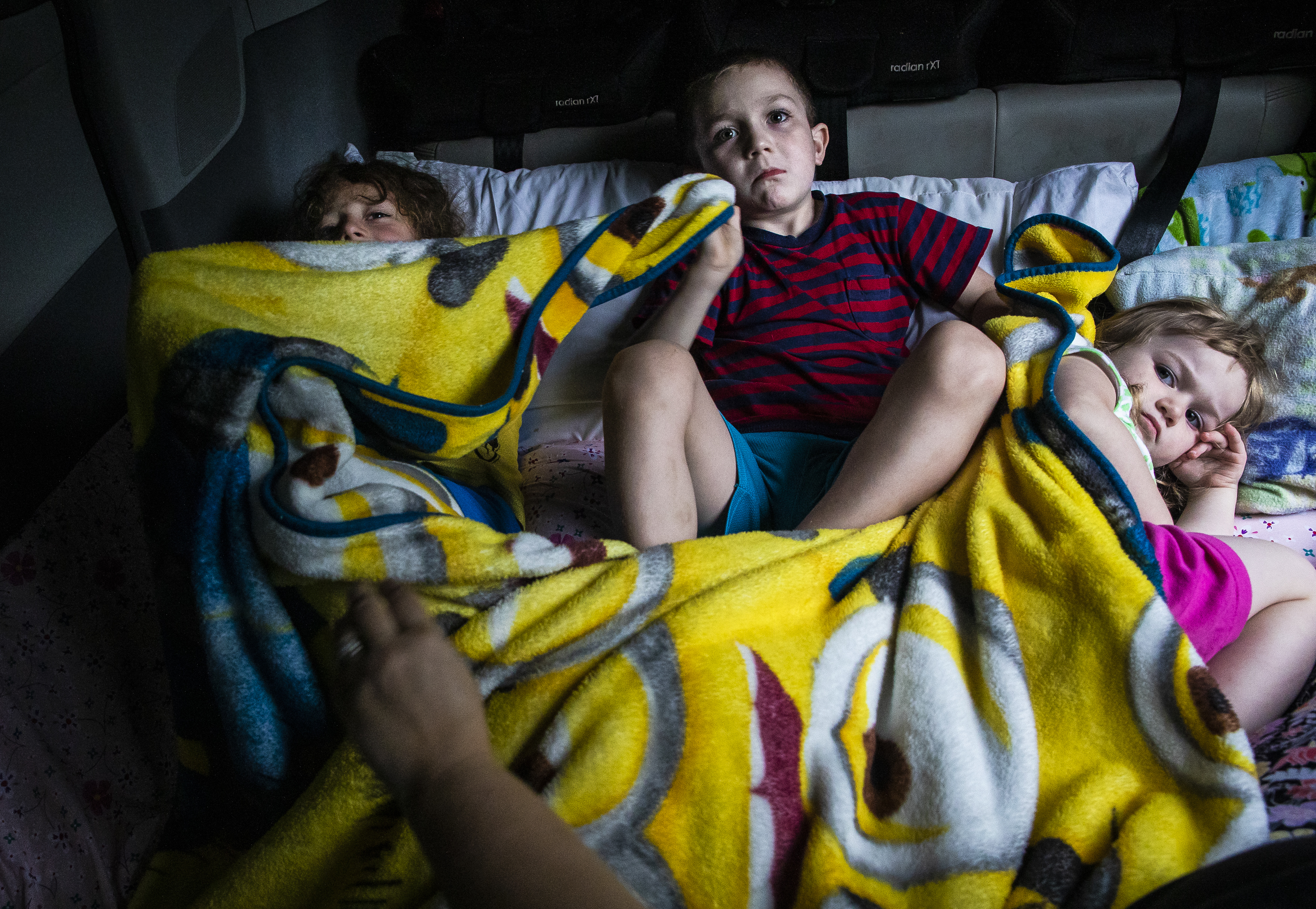 Evan, Dylan, and Laya watched a movie while getting ready for bed in the back of their family's van at the campground. Because of the children’s special needs and Dylan’s flight risk due to his autism, the children slept in the van with the doors zip-tied closed.