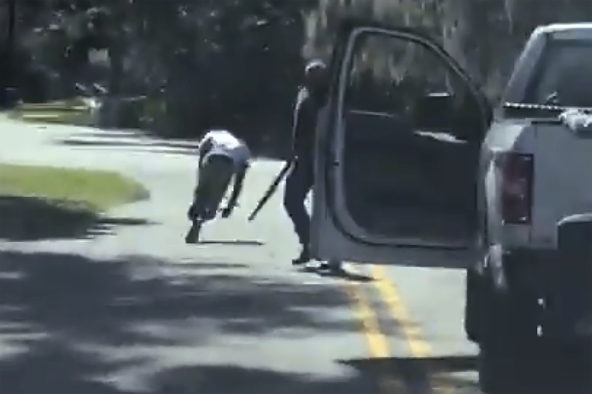 In this image from video posted on Twitter Tuesday, May 5, 2020, Ahmaud Arbery stumbled and fell to the ground after being shot as Travis McMichael stood by holding a shotgun in a neighborhood outside Brunswick, Ga., on Feb. 23, 2020.