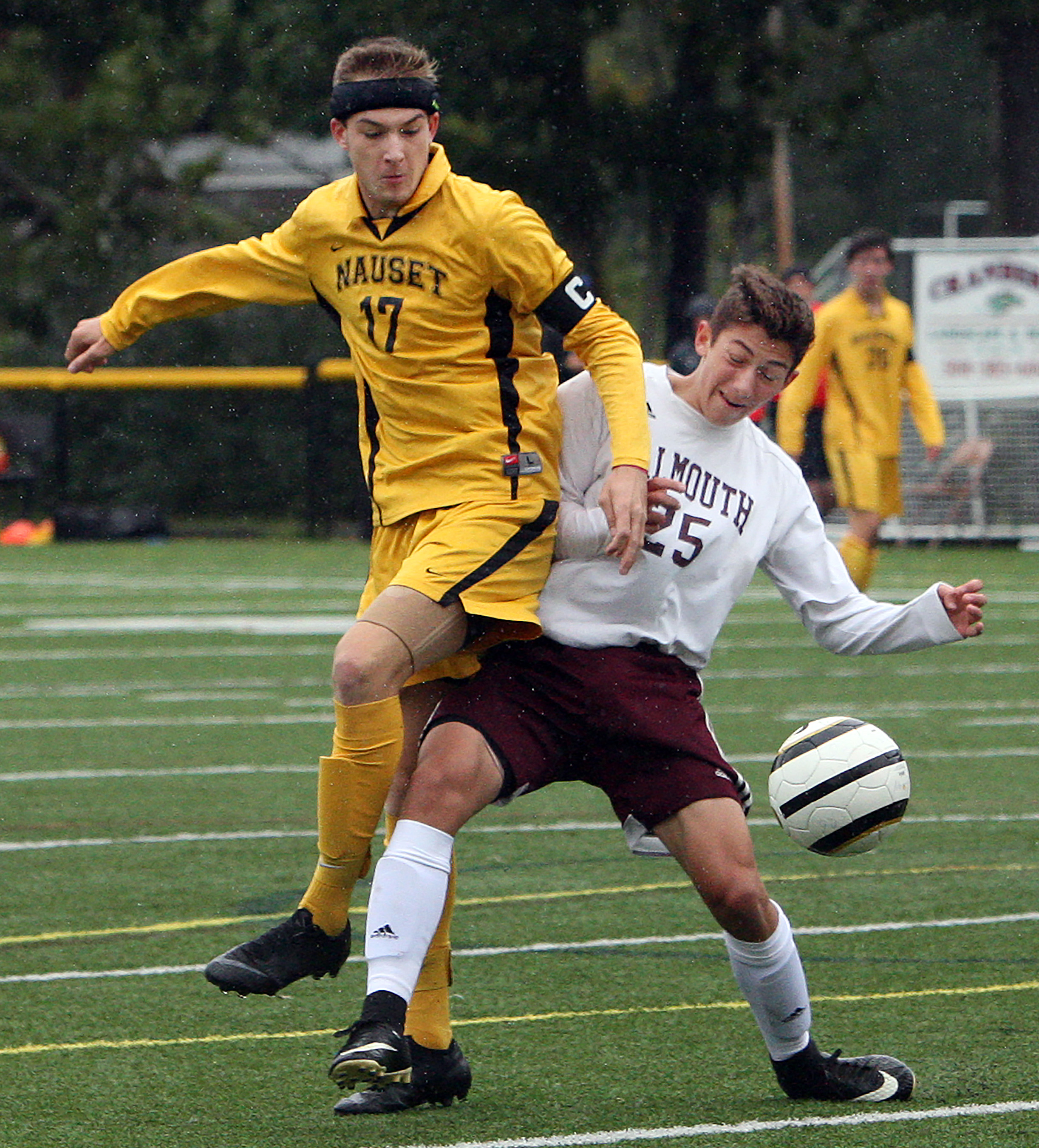 Nauset boys’ soccer captain Avery Santoro (18) battles Falmouth’s Colin Mastriano for possession.