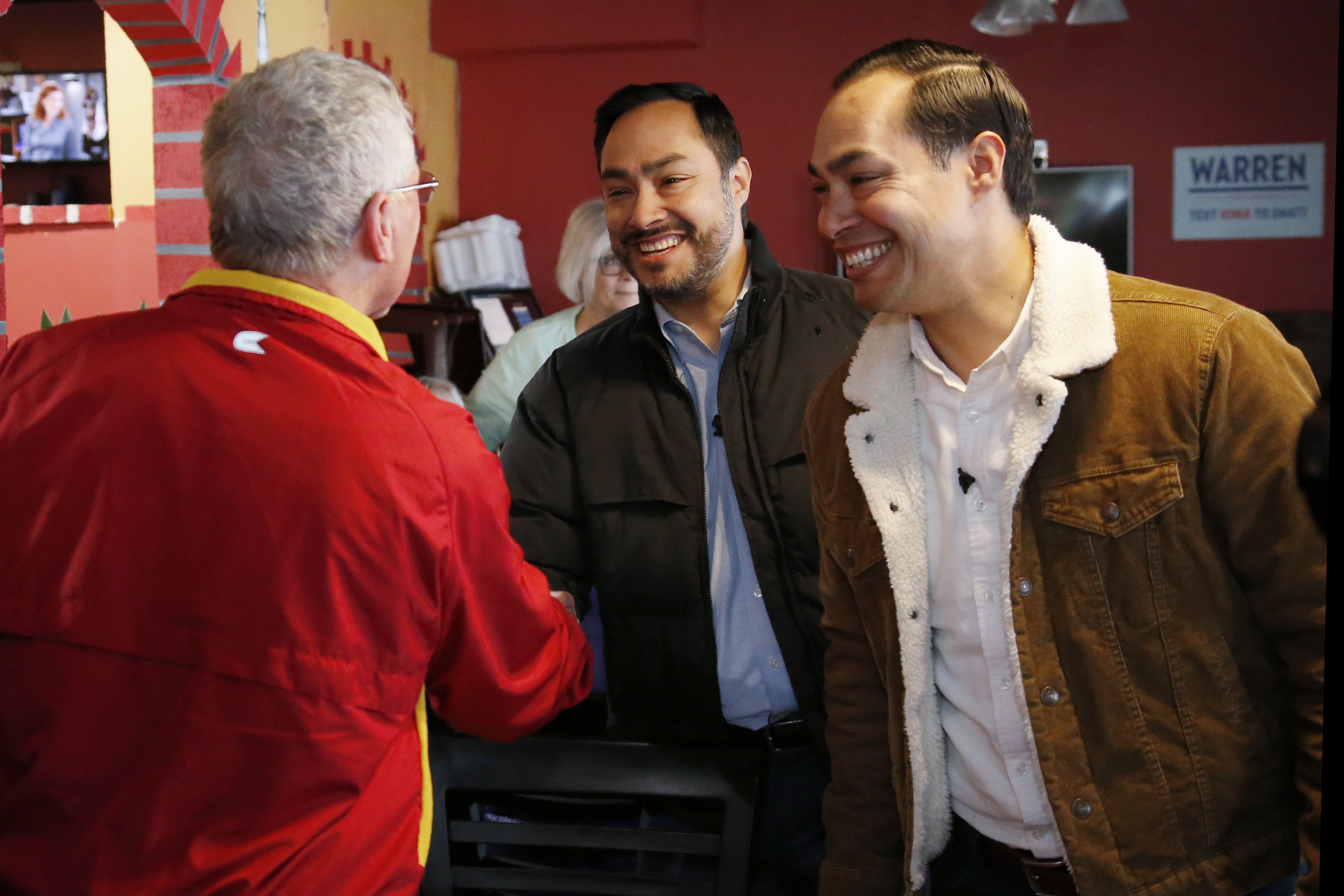Representative Joaquin Castro, left, and his brother Julian Castro, right, former Secretary of Housing and Urban Development, greet an Elizabeth Warren supporter Wednesday, Jan. 22, 2020, as they campaign for her in Denison, Iowa. (AP Photo/Sue Ogrocki)