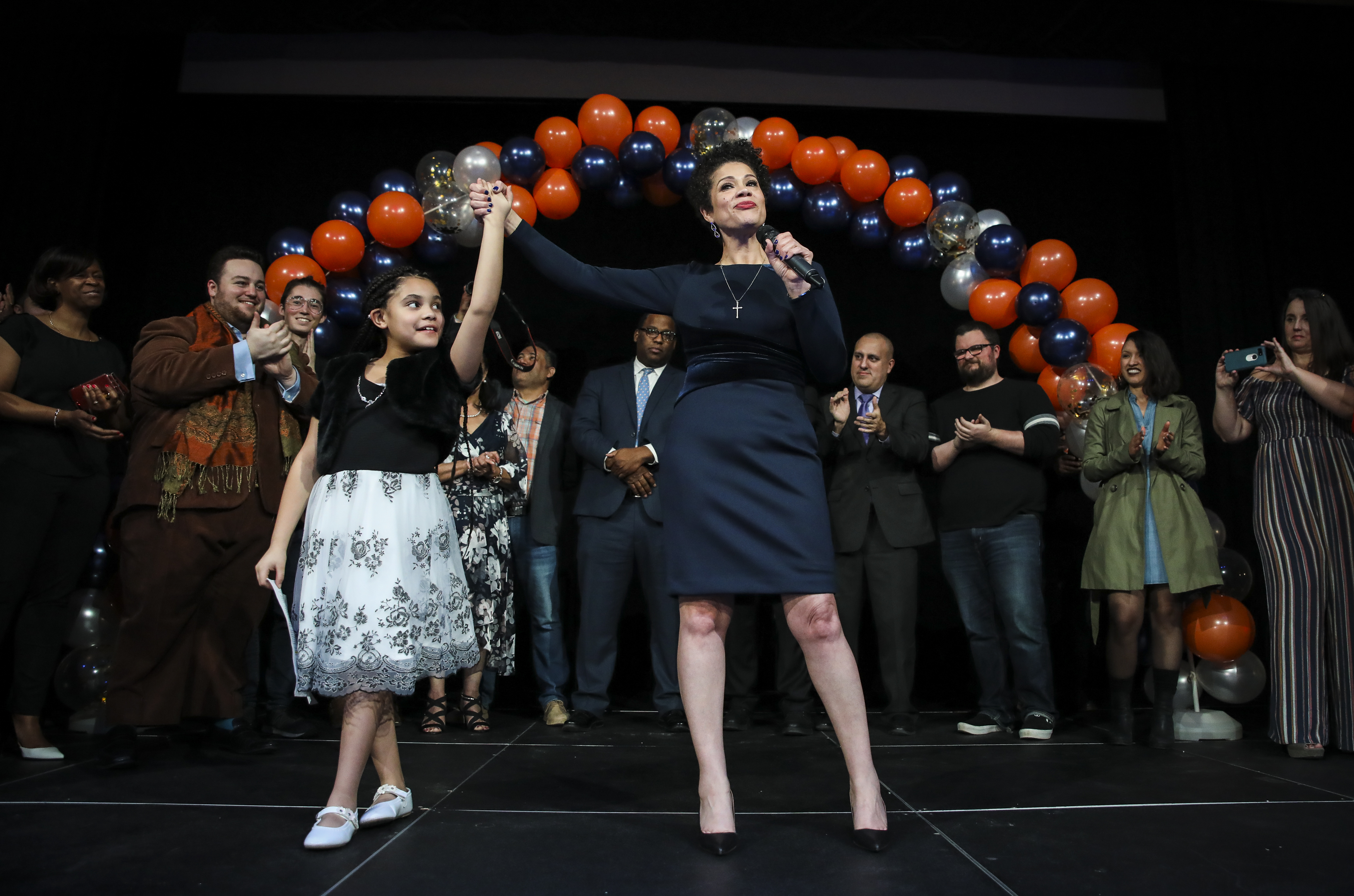 Newly elected councilor Julia Mejia lifted up the hand of her daughter, Annalise Cooper, 9, as they celebrated Mejia’s victory at an inaugural party in Roxbury.