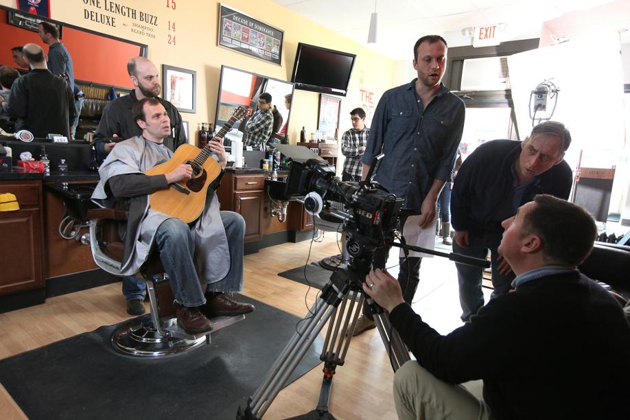 Moock, with guitar, shoots his “When I Get Bald” music video at a Melrose barber shop.