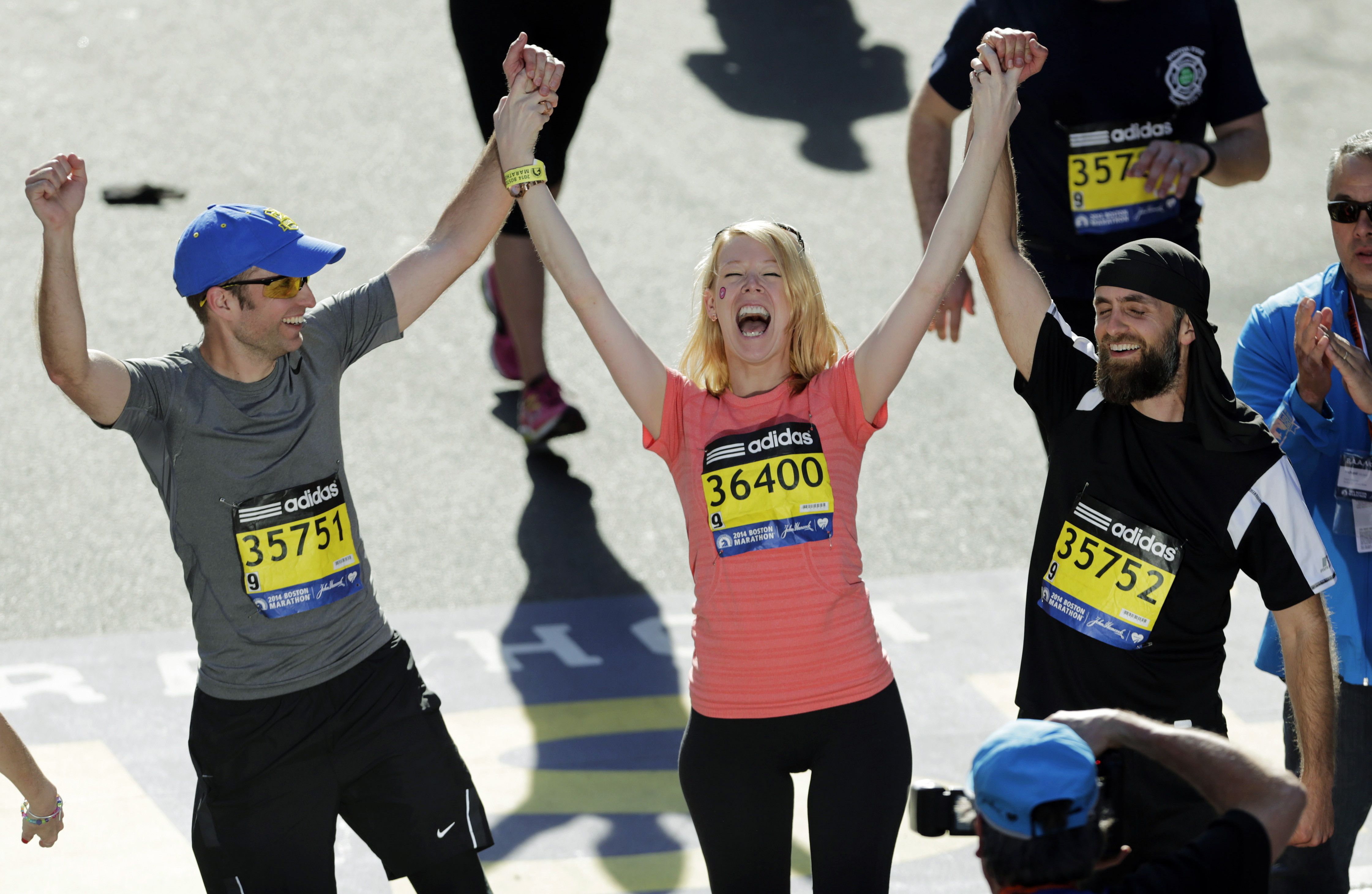 Adrianne Haslet is flanked by brothers Timothy (left) and David as she crosses the finish line after completing a short distance in 2014, the year after surviving the Marathon bombing.