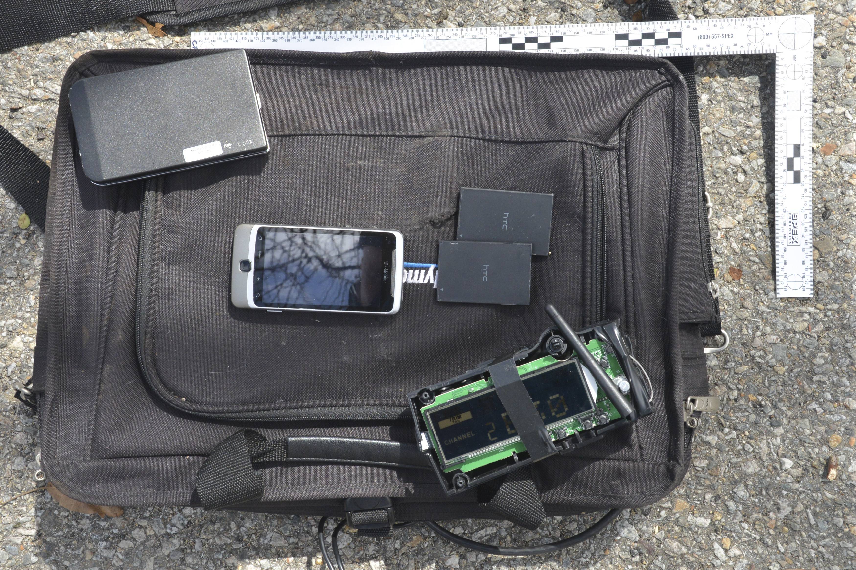 A black laptop case, a portable hard drive (top left), a cellphone and spare batteries (center), and a homemade remote control device (bottom right) were entered as evidence during the Marathon bombing trial last week.