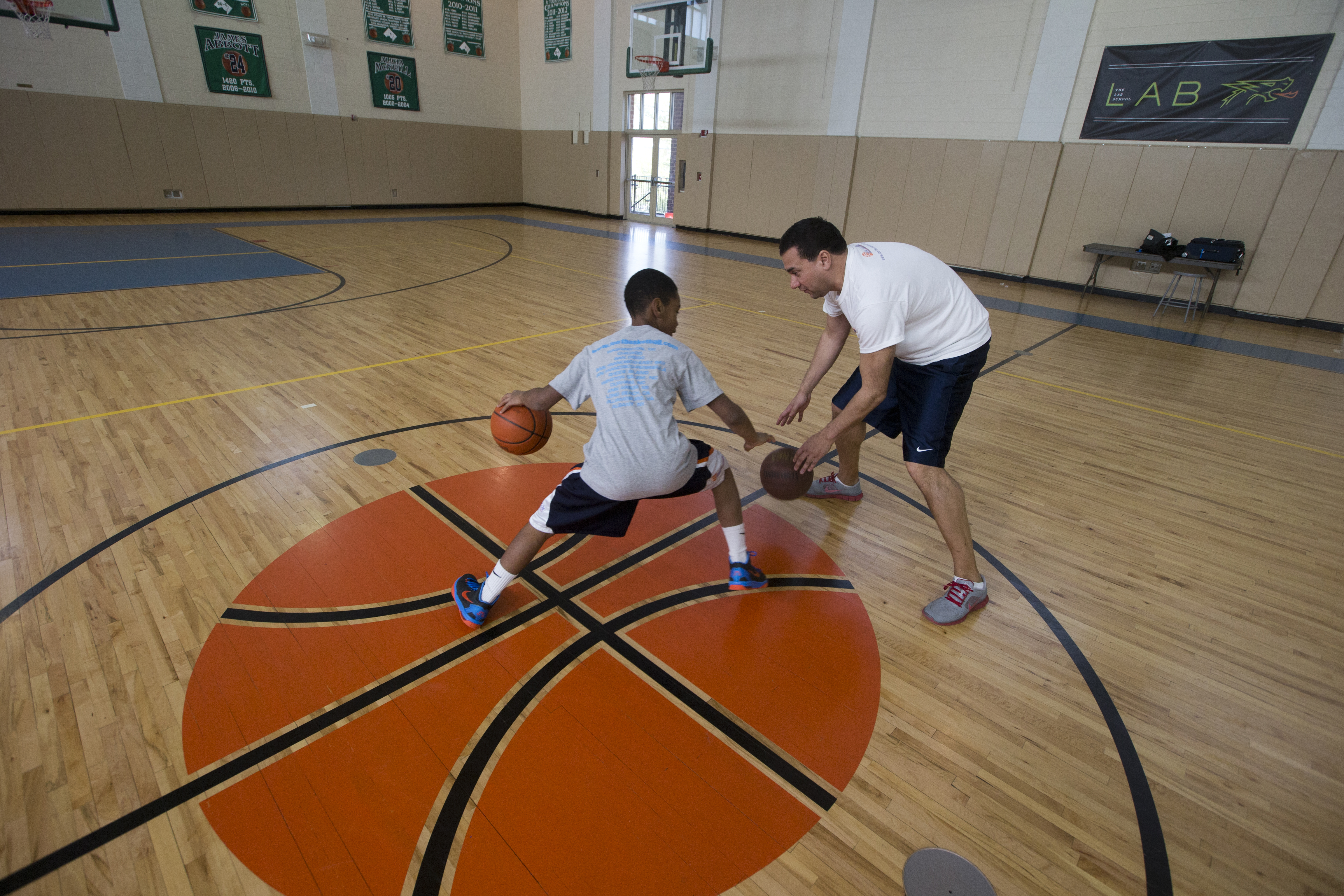 Decerega, right, instructing Brandon Milligan, is a trainer at One on One Basketball.