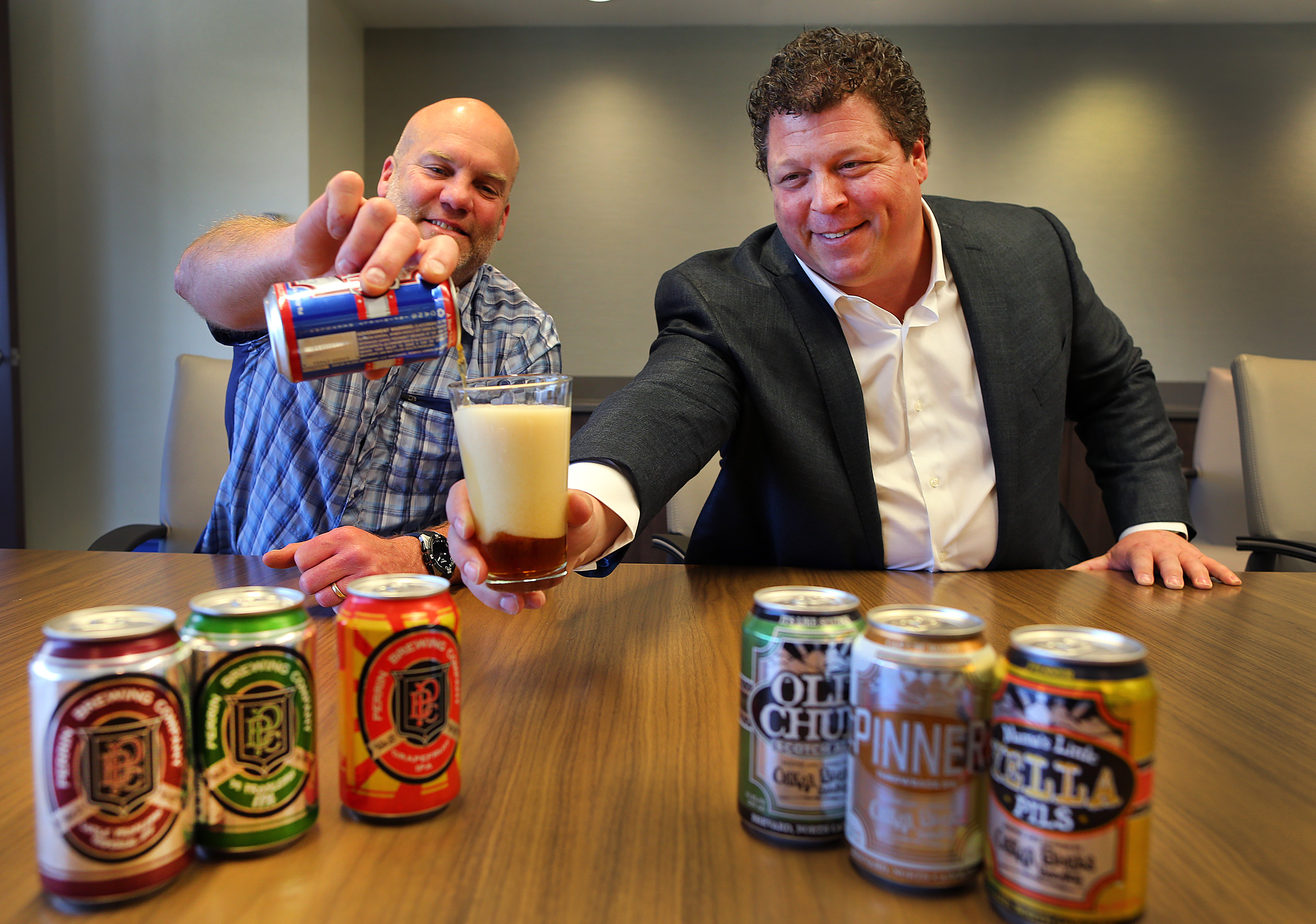 Dale Katechis (left), founder of Oskar Blues brewing, and Fireman Capital managing partner, Dan Fireman, take a sample of one of Katechis’s beers.
