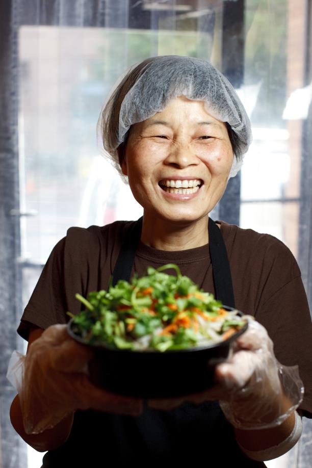 Fang, a cook at Gene’s Chinese Flatbread Cafe, holds the No. 9, cumin lamb on hand-pulled noodles.