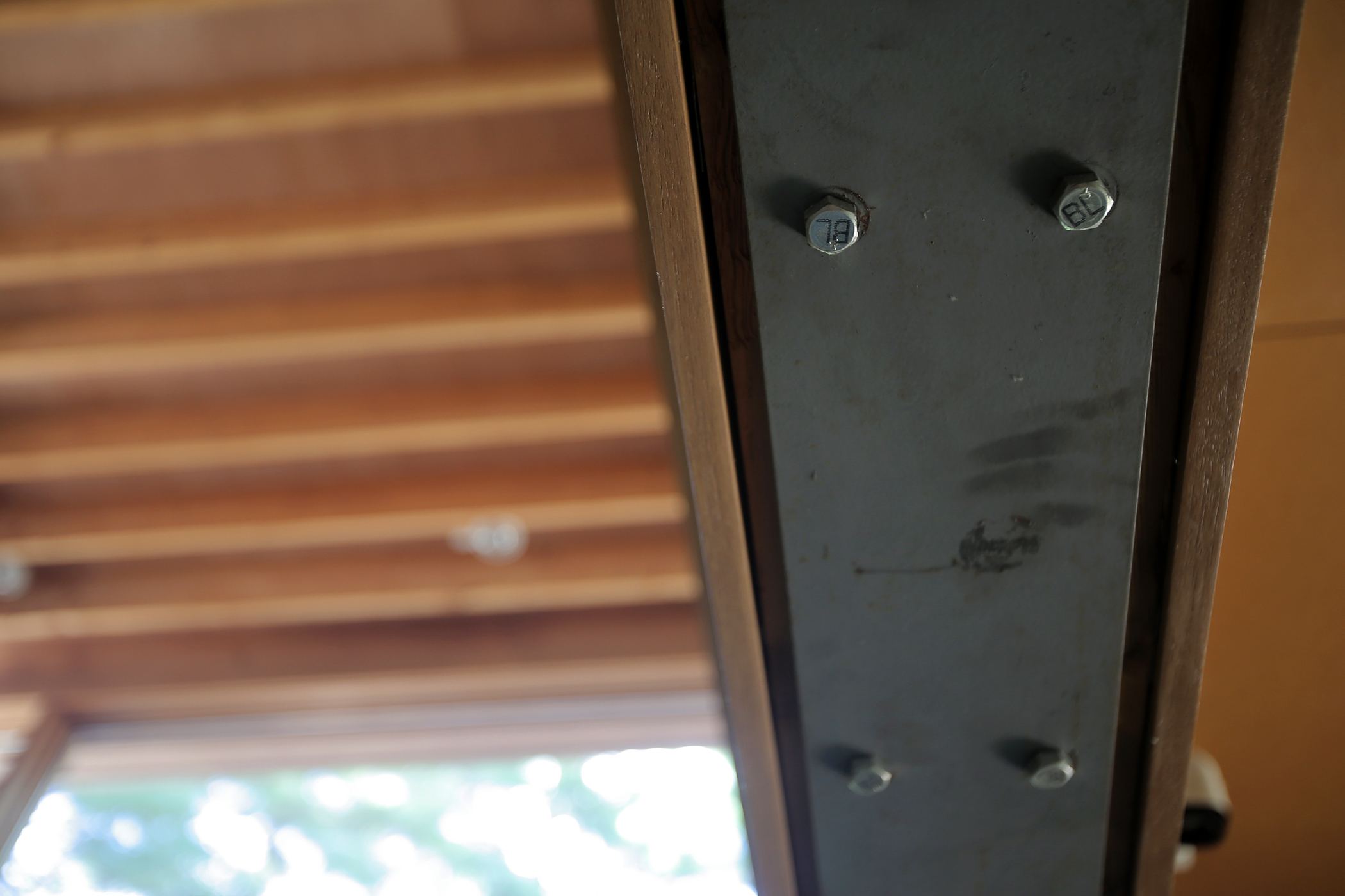 Silver carriage bolts in the black I-beam running down the central hallway, or gallery