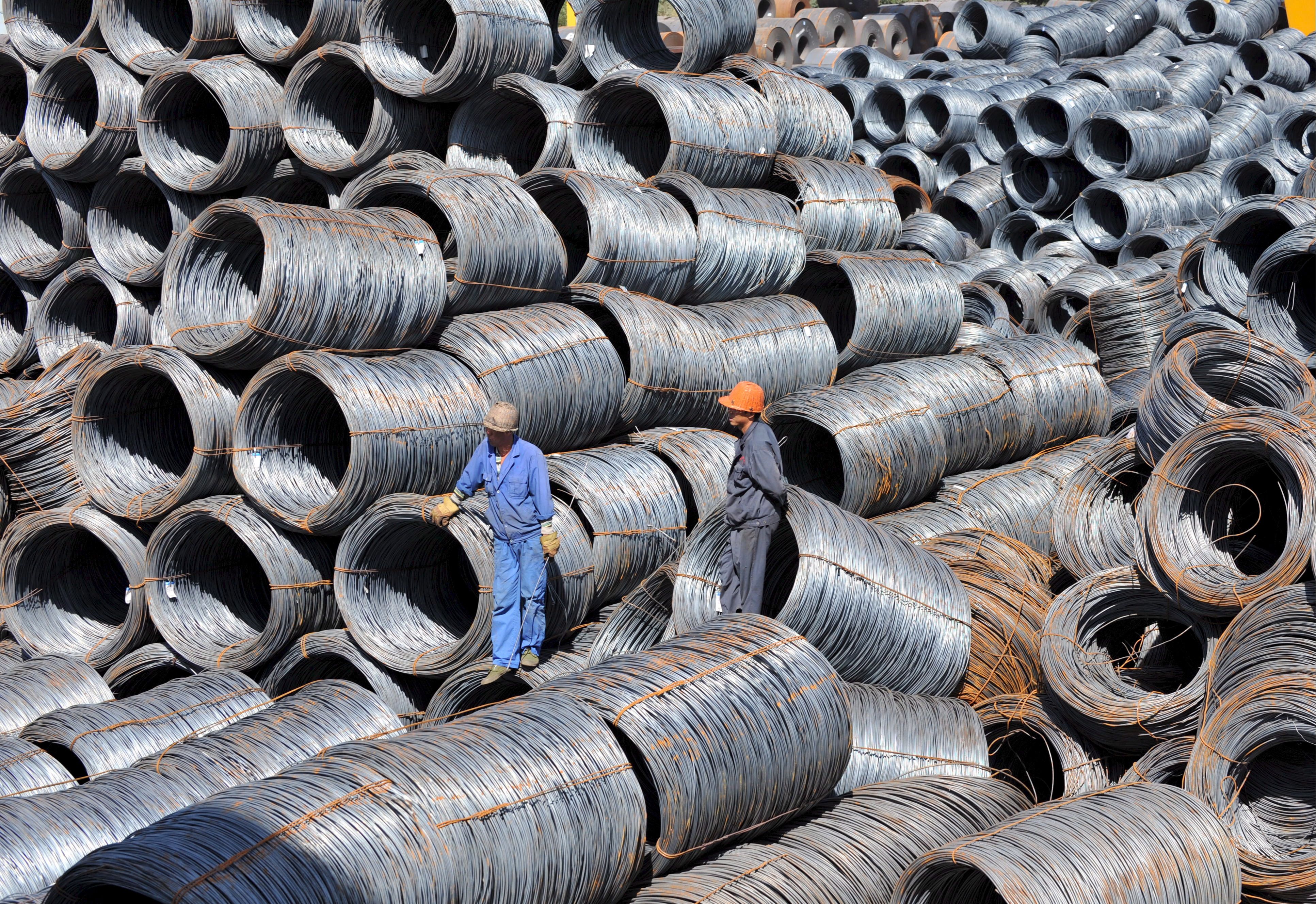 Workers inspected stock of rolls of steel in a transhipment yard in northeast China's Shenyang.