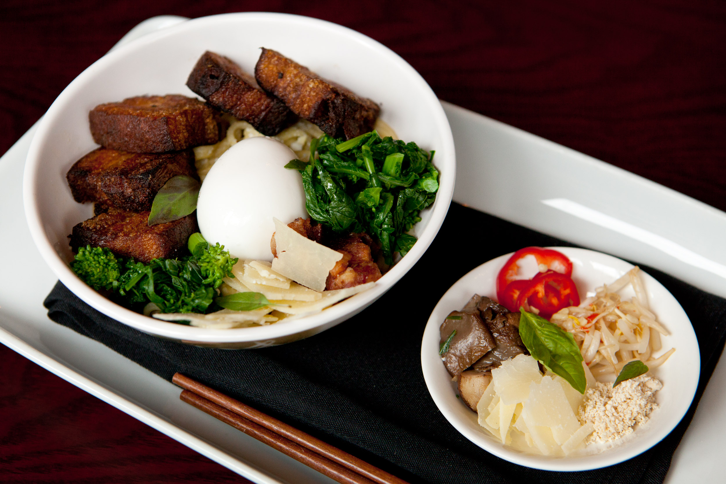 Ramen noodle “carbonara” in guanciale-tinted dashi with roast pork belly, poached egg, broccoli rabe, and Parmesan.