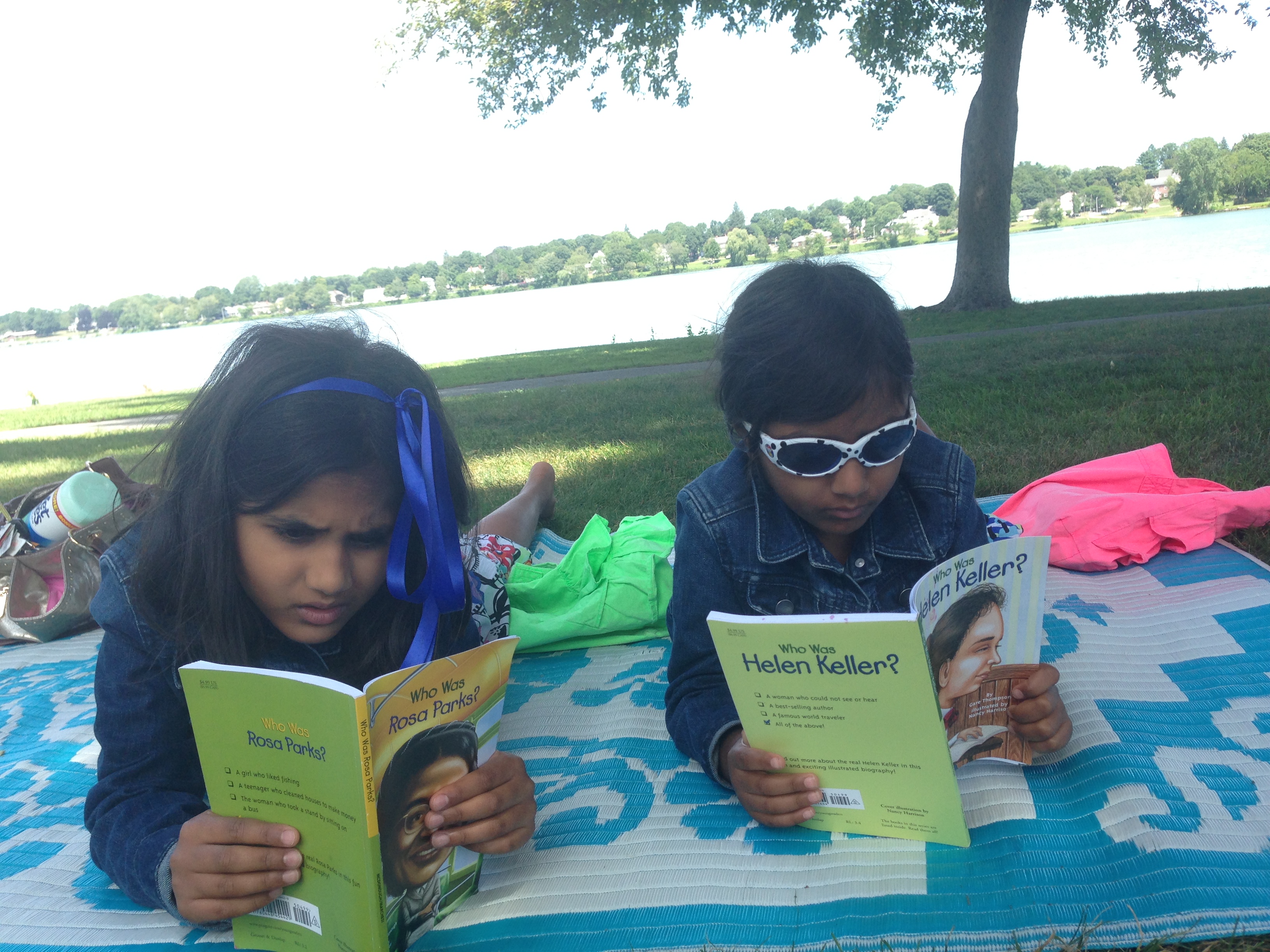 Jia Kumar, 8, and her sister Bela, 6, read historical biographies at Lake Quannapowitt in Wakefield last summer.
