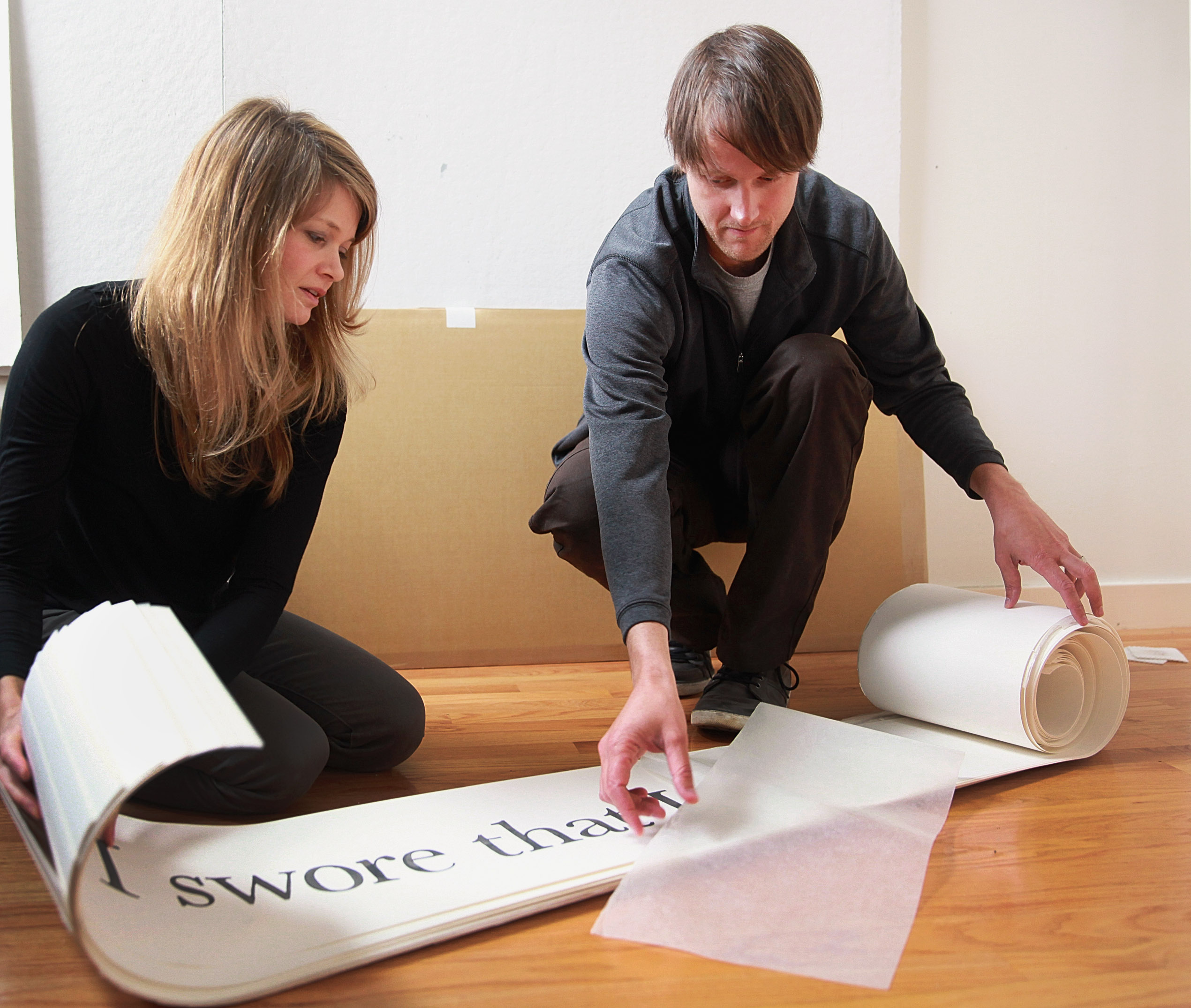 Artists Kelly Sherman (left) and Halsey Burgund unroll panels that are part of their audio-visual-Internet project on patient interactions with the often-impersonal health care system.