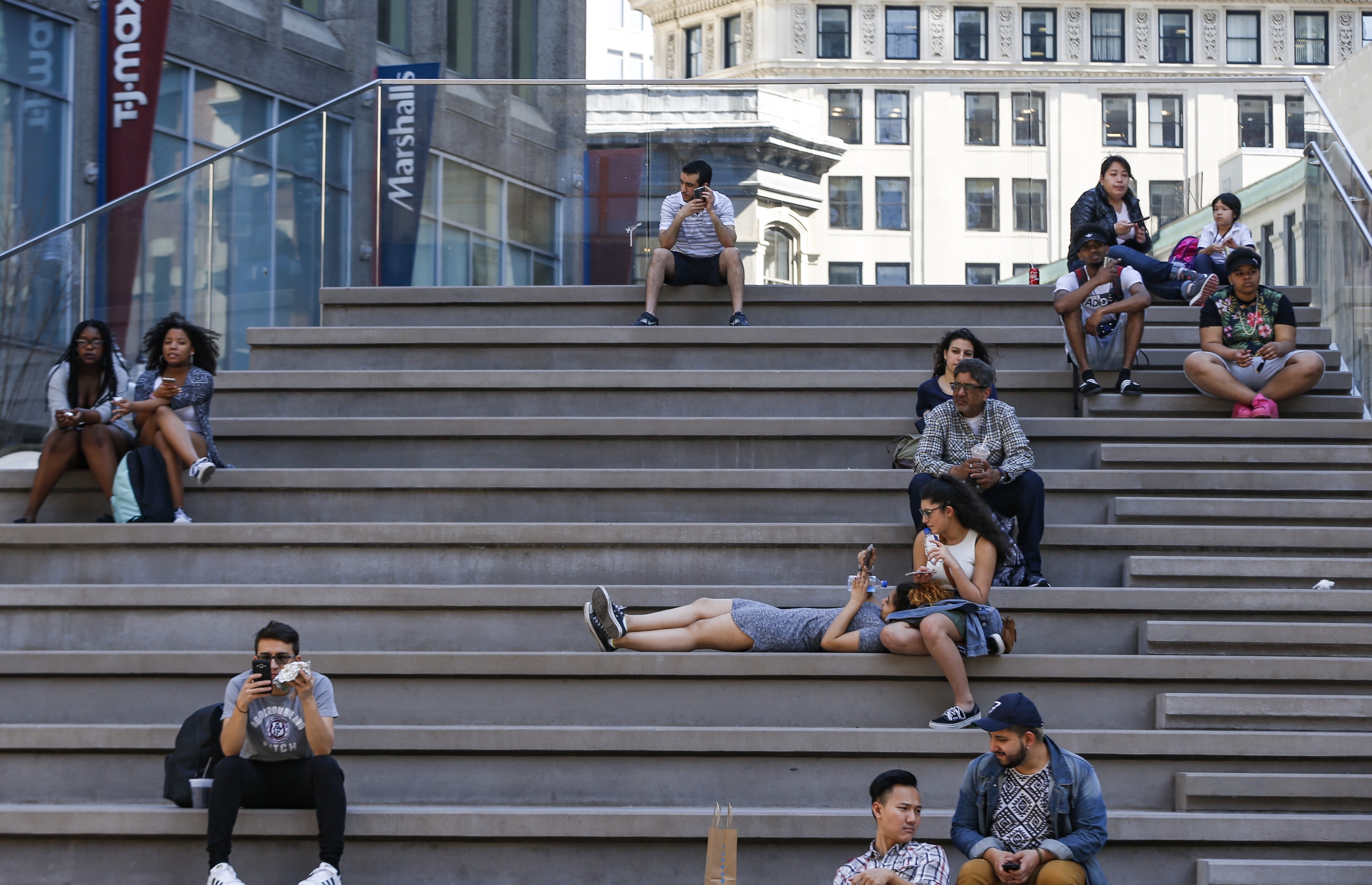 People sat on stairs on Washington Street Tuesday, enjoying the nice weather — a sight that, a few years ago, would have been out of place.