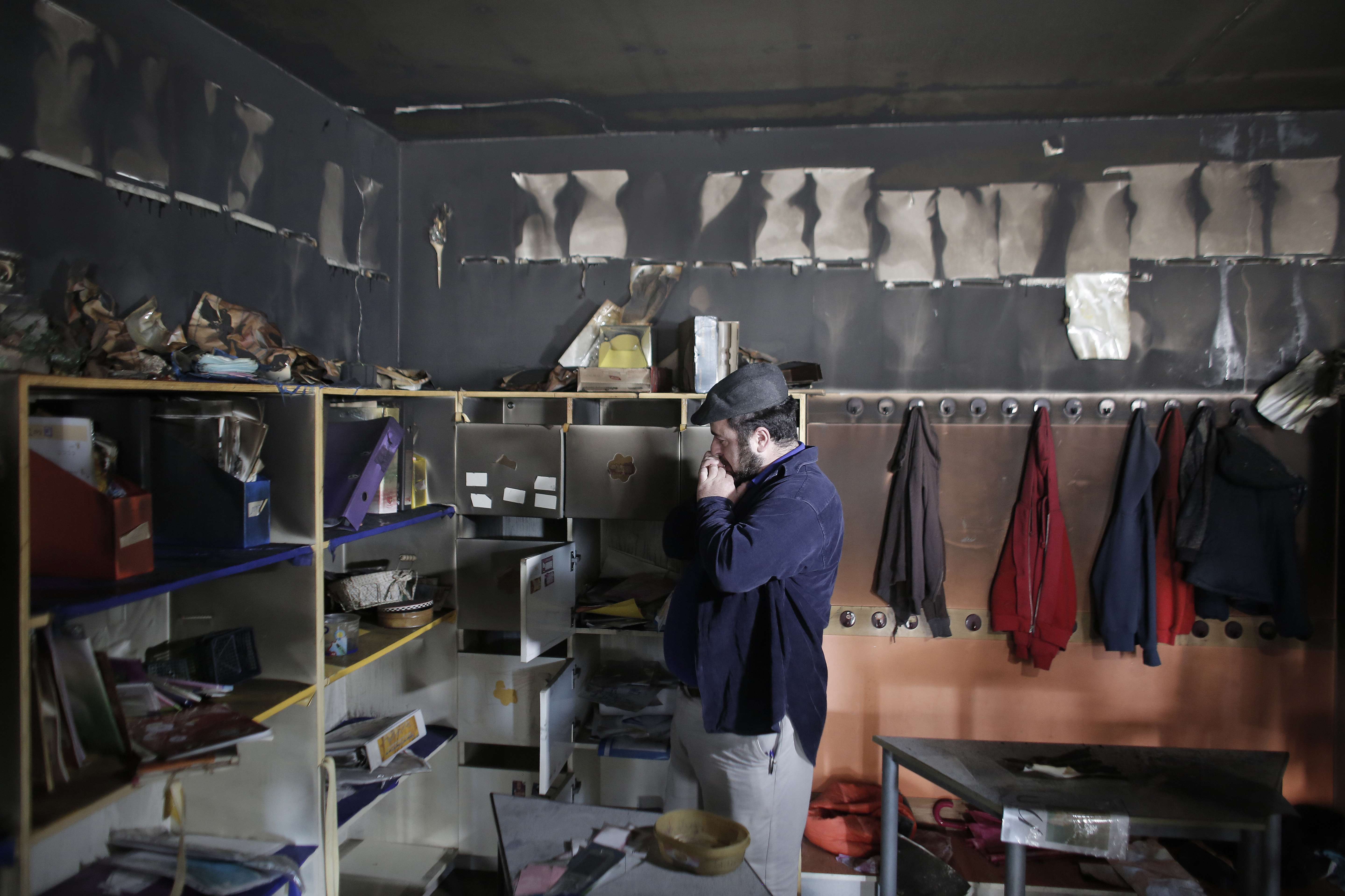 A man inspects damage on Nov. 30, in the aftermath of an arson attack that targeted first-grade classrooms at a bilingual Jewish-Arab school in Jerusalem.