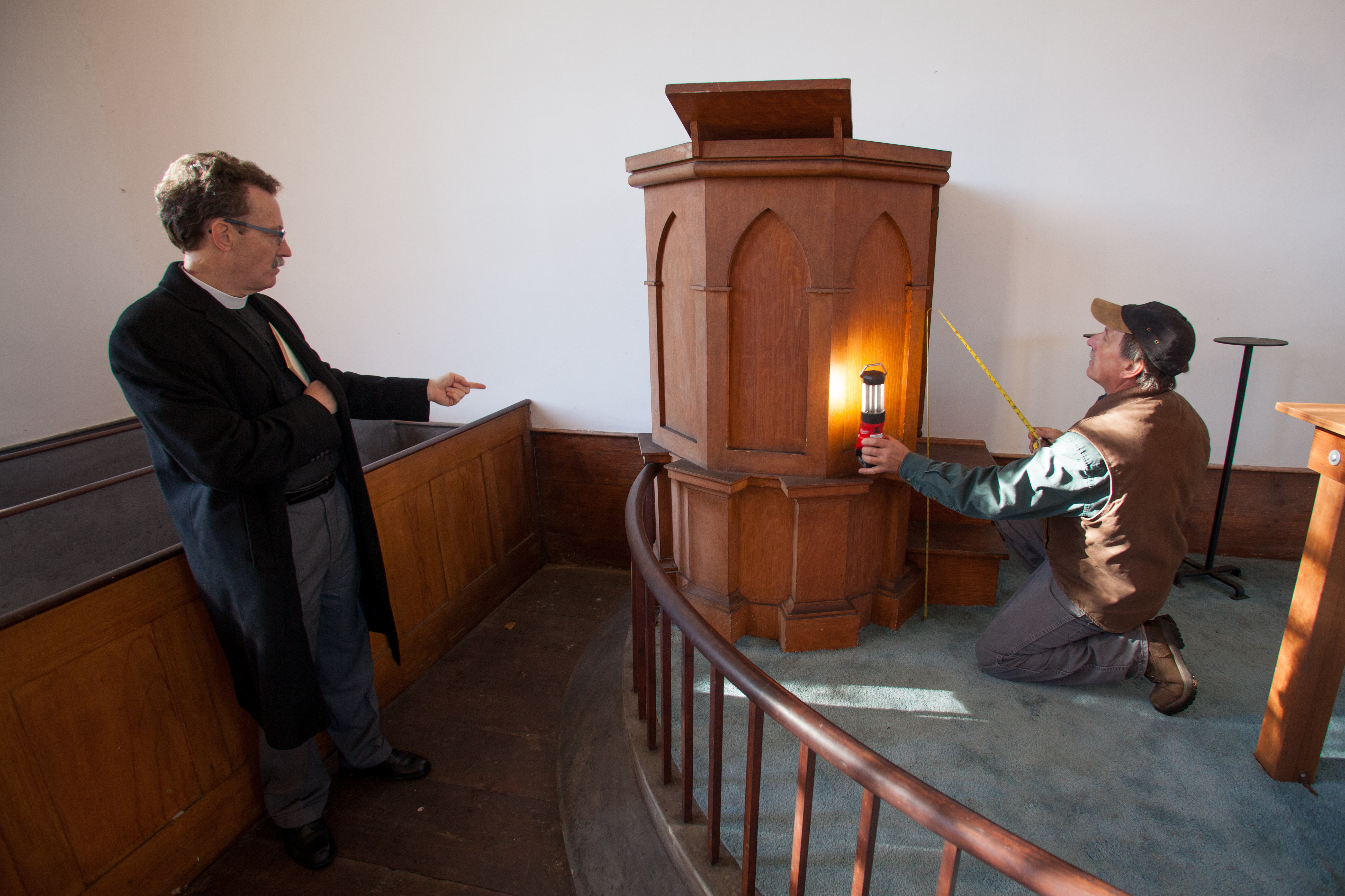 The Reverend Stephen T. Ayres of Old North Church (left) and restoration expert Steve Marshall inspected the pulpit at St. Paul’s Church.