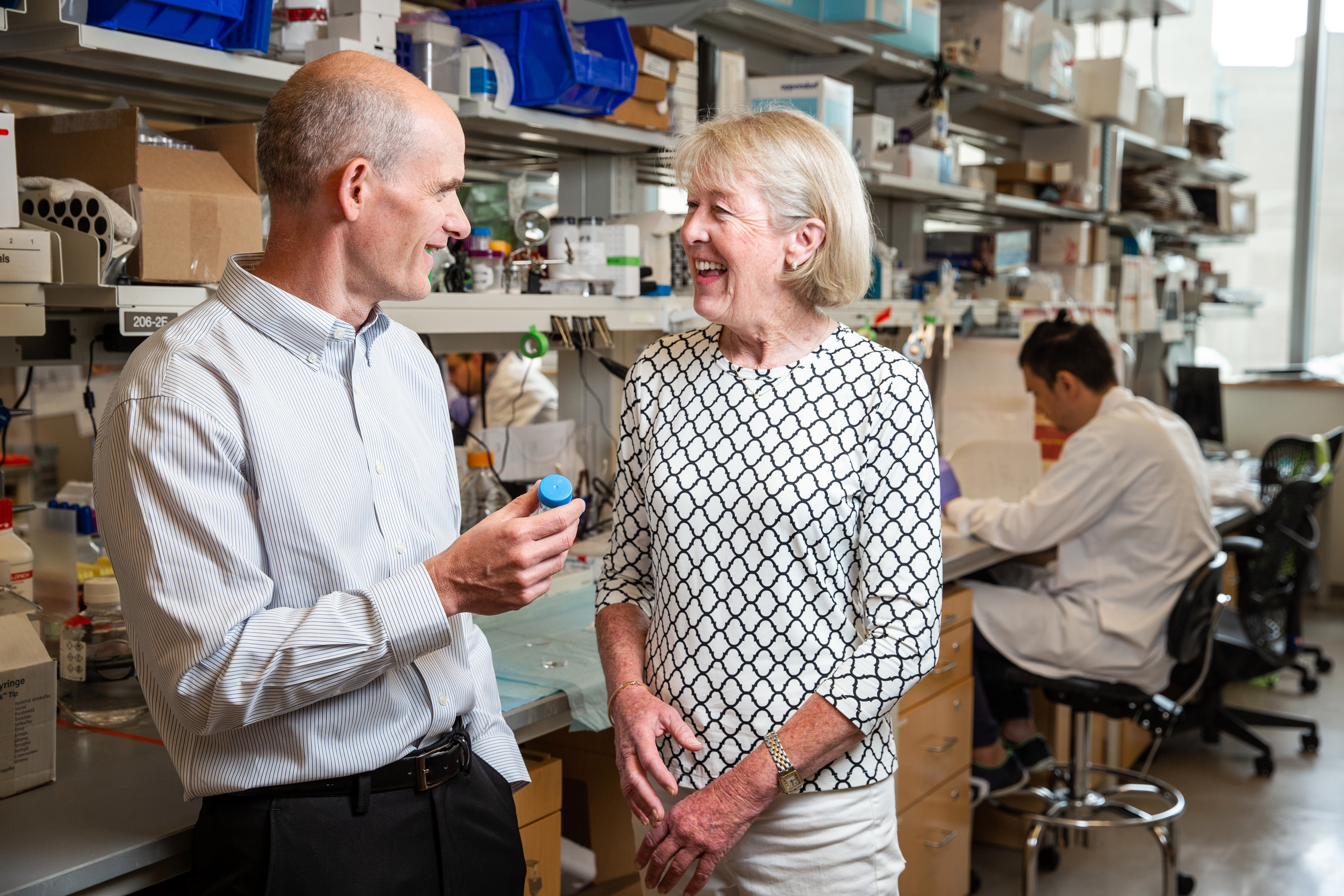 Mary Gooding talks with Harvard bioengineer David Mooney in his lab. He developed a vaccine implant being used to treat her melanoma.
