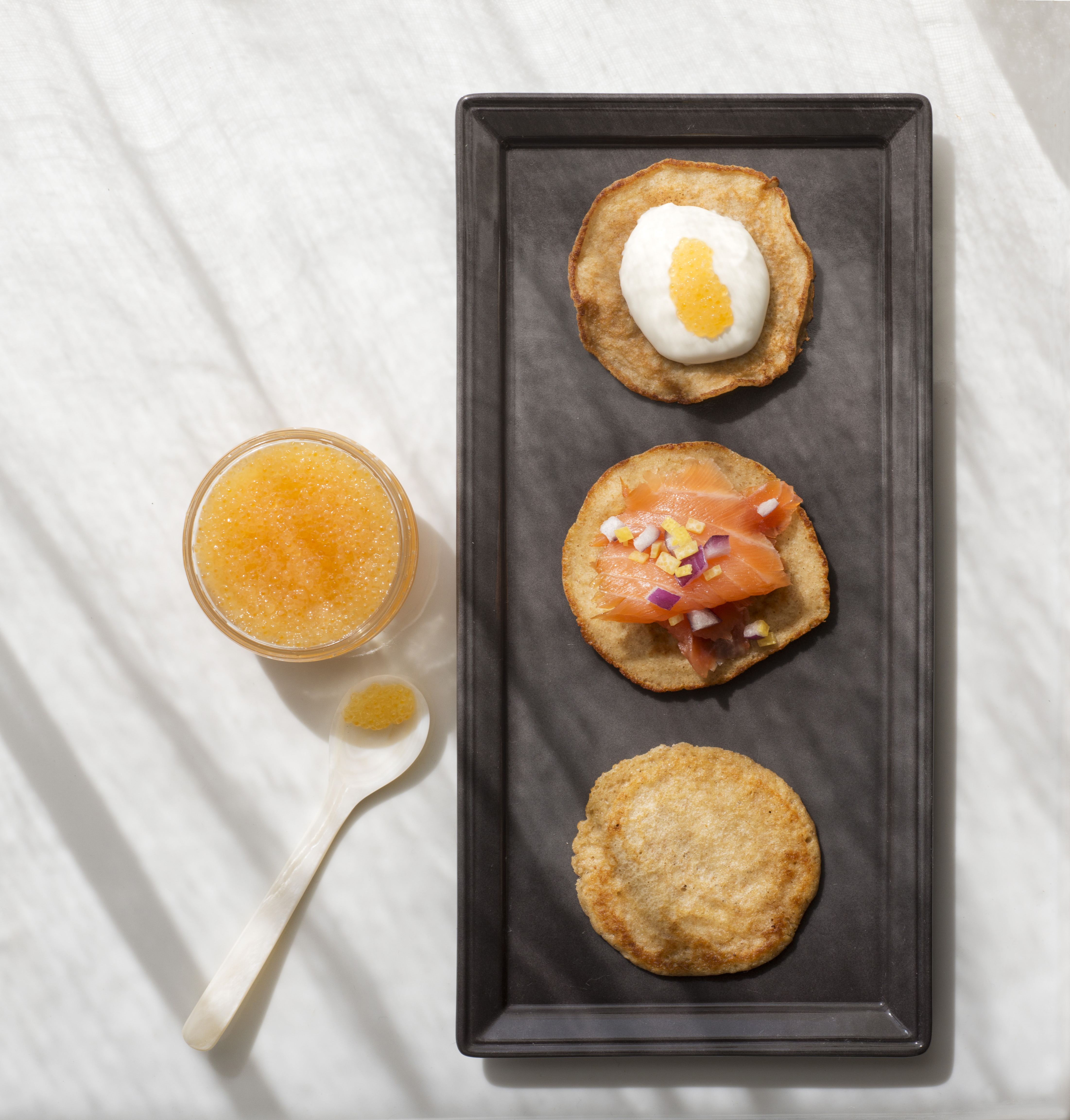 Sour cream and caviar are delectable blini toppings, as are smoked salmon with red onions and lemon zest. Classic Russian blini are prepared with buckwheat flour and yeast; this quicker version uses whole wheat flour and baking powder.
