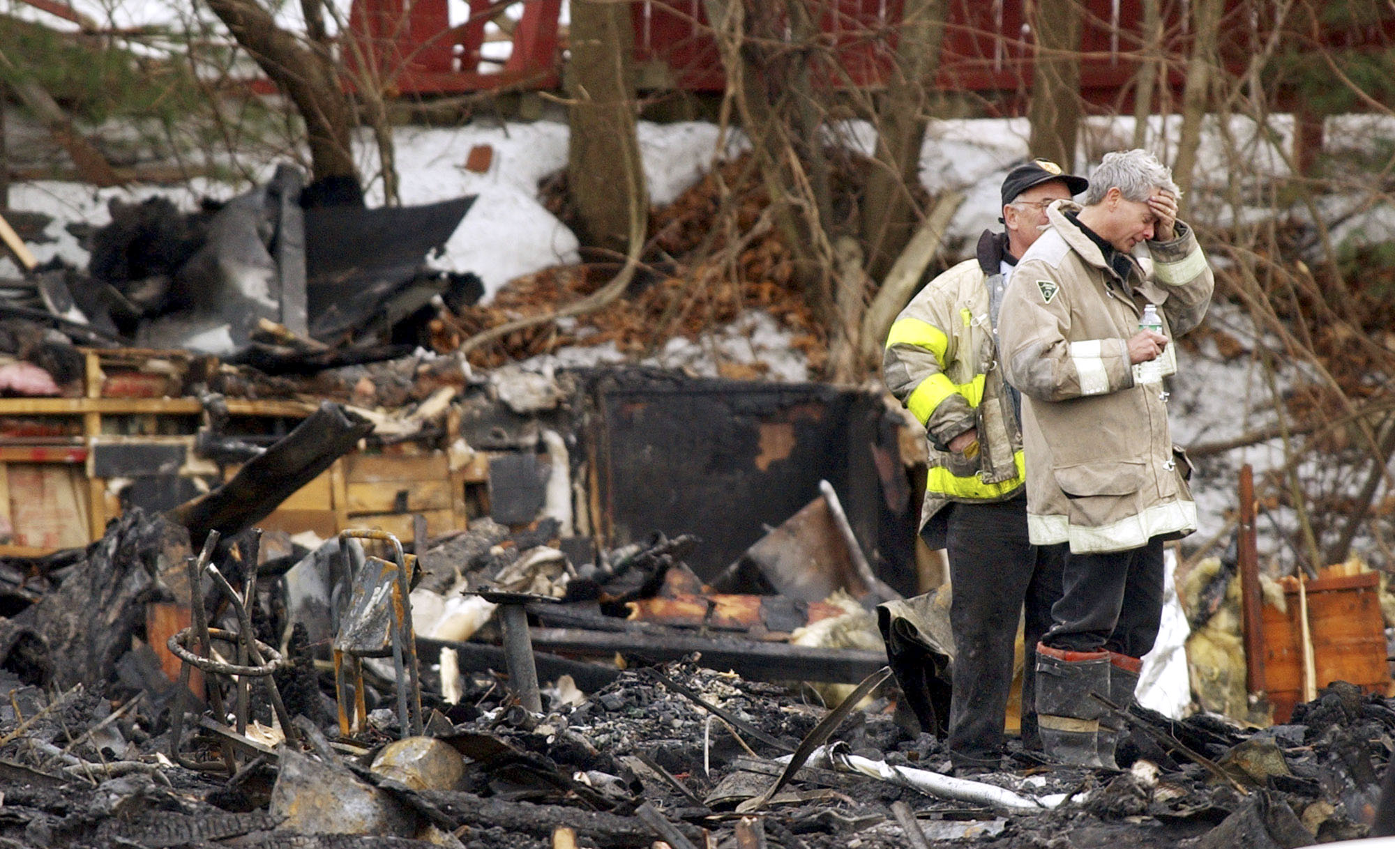 A firefighter held his hand to his forehead as he stood amidst the rubble after the fire.